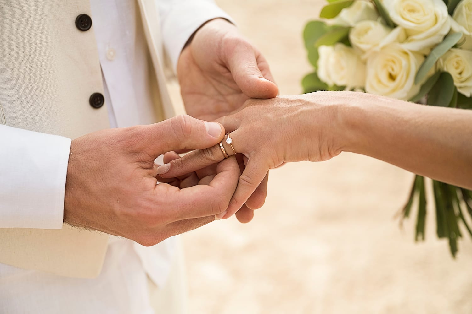 a man putting a ring on a woman's hand