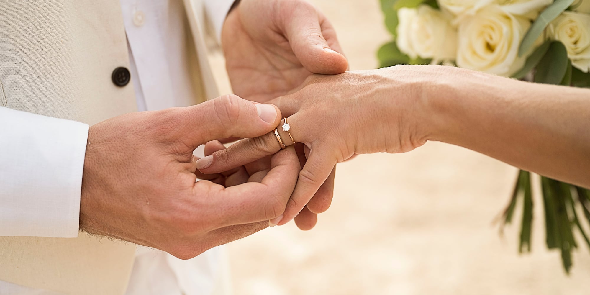 a man putting a ring on a woman's hand