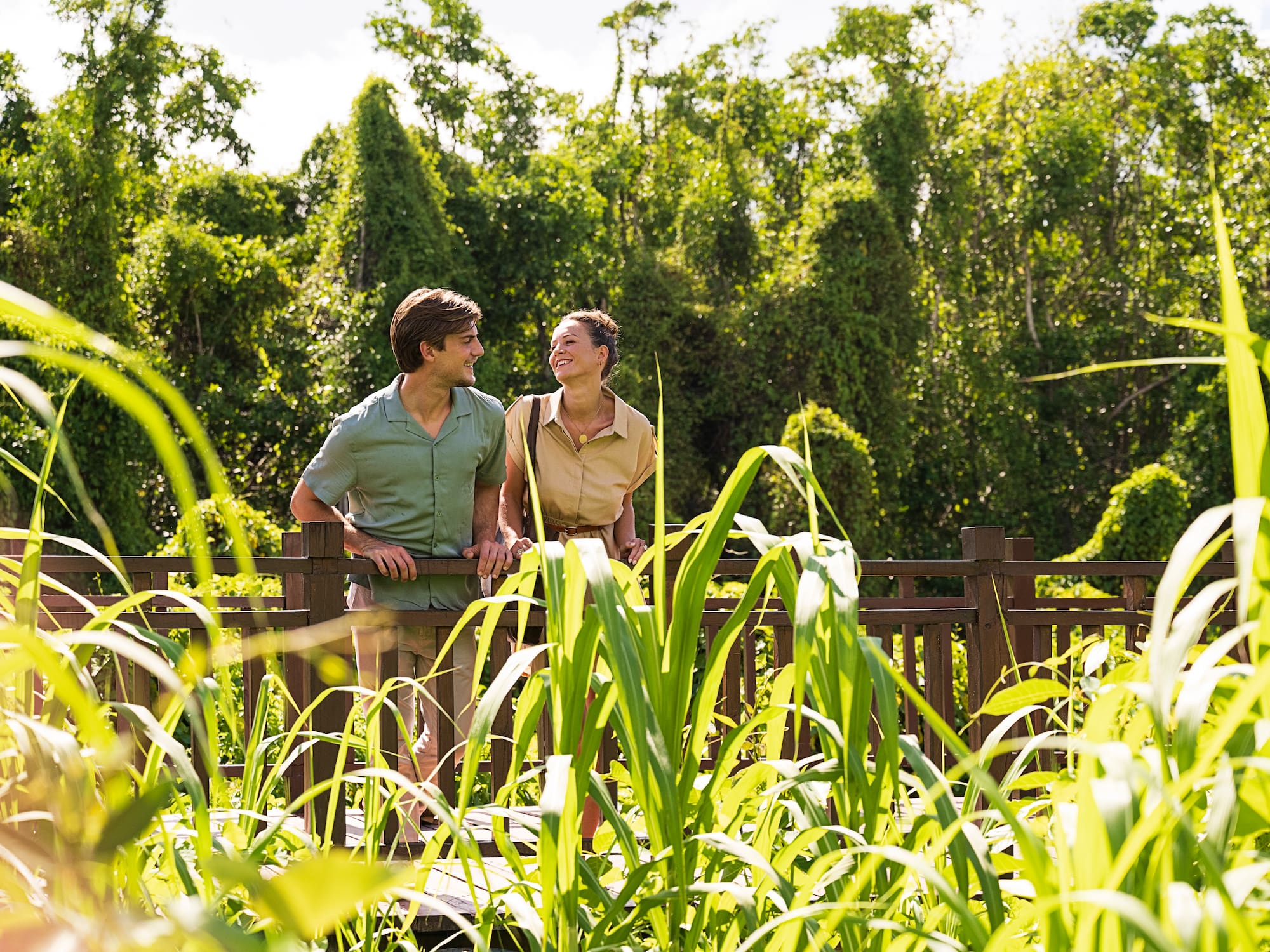 a man and woman standing on a wooden fence