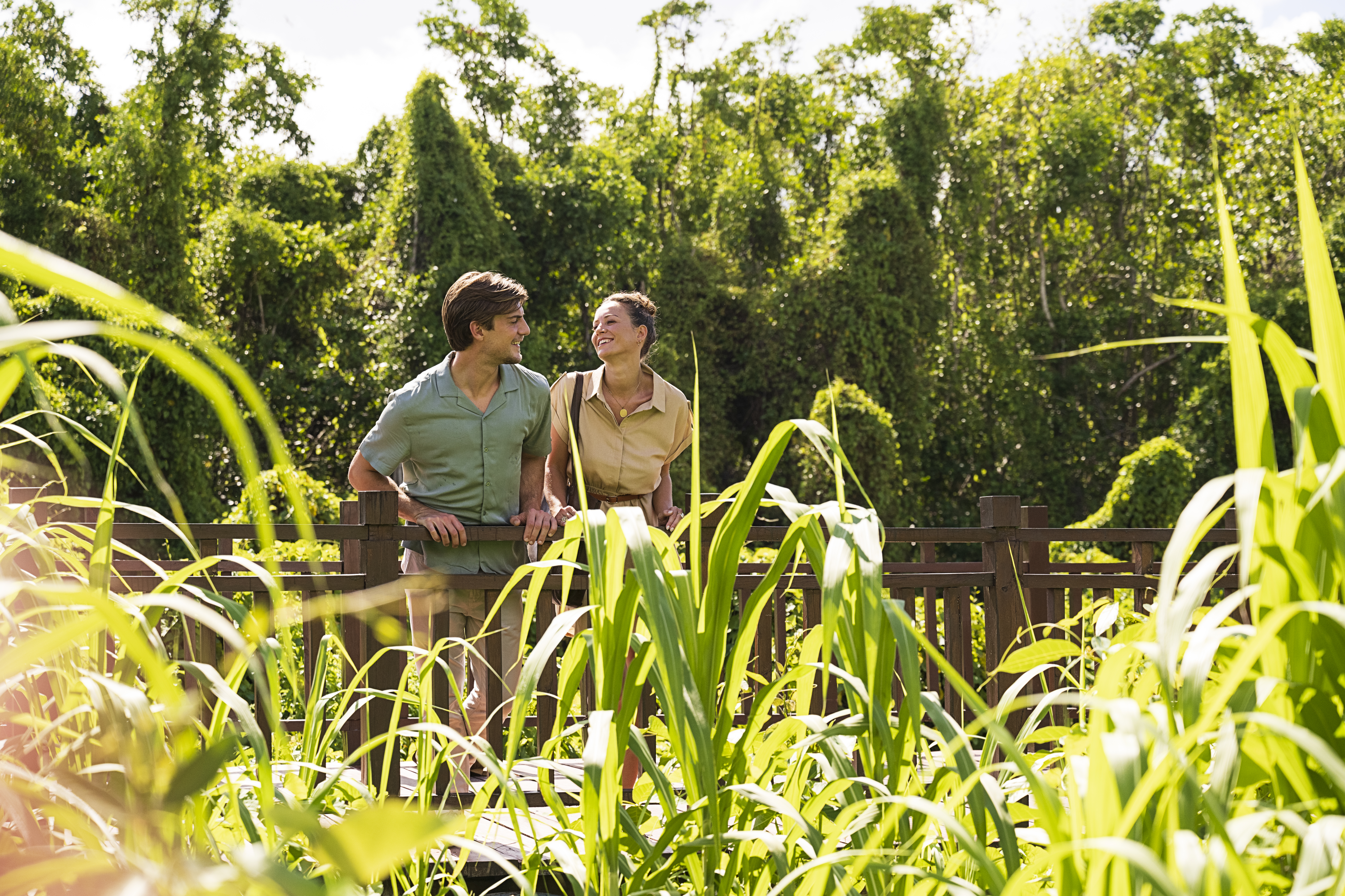 a man and woman standing on a wooden fence