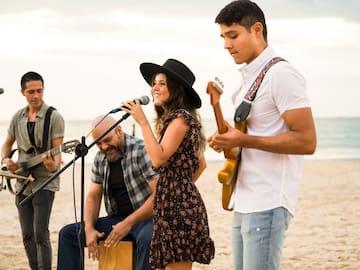 a group of people playing instruments on a beach