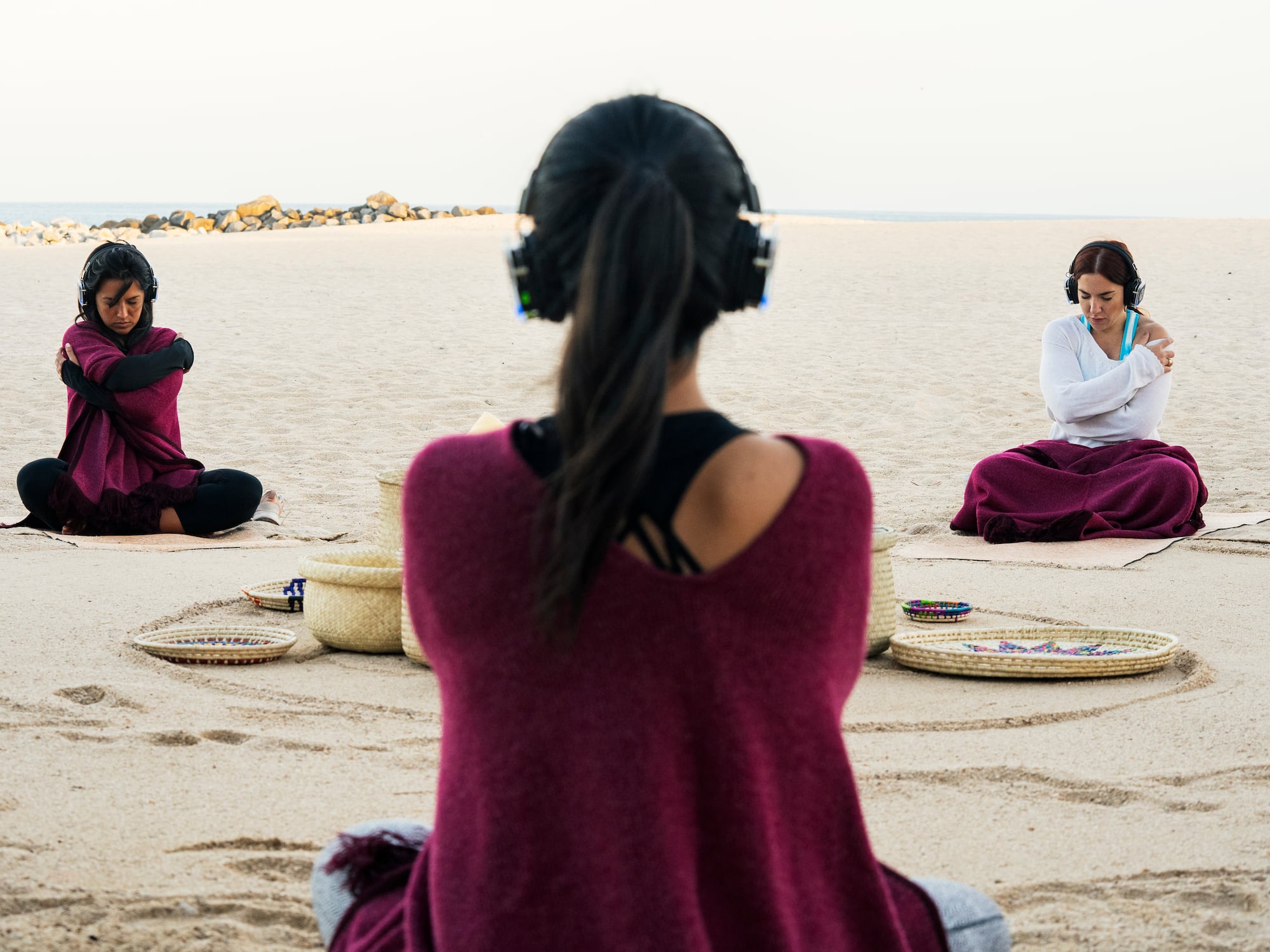 a group of people sitting on the sand