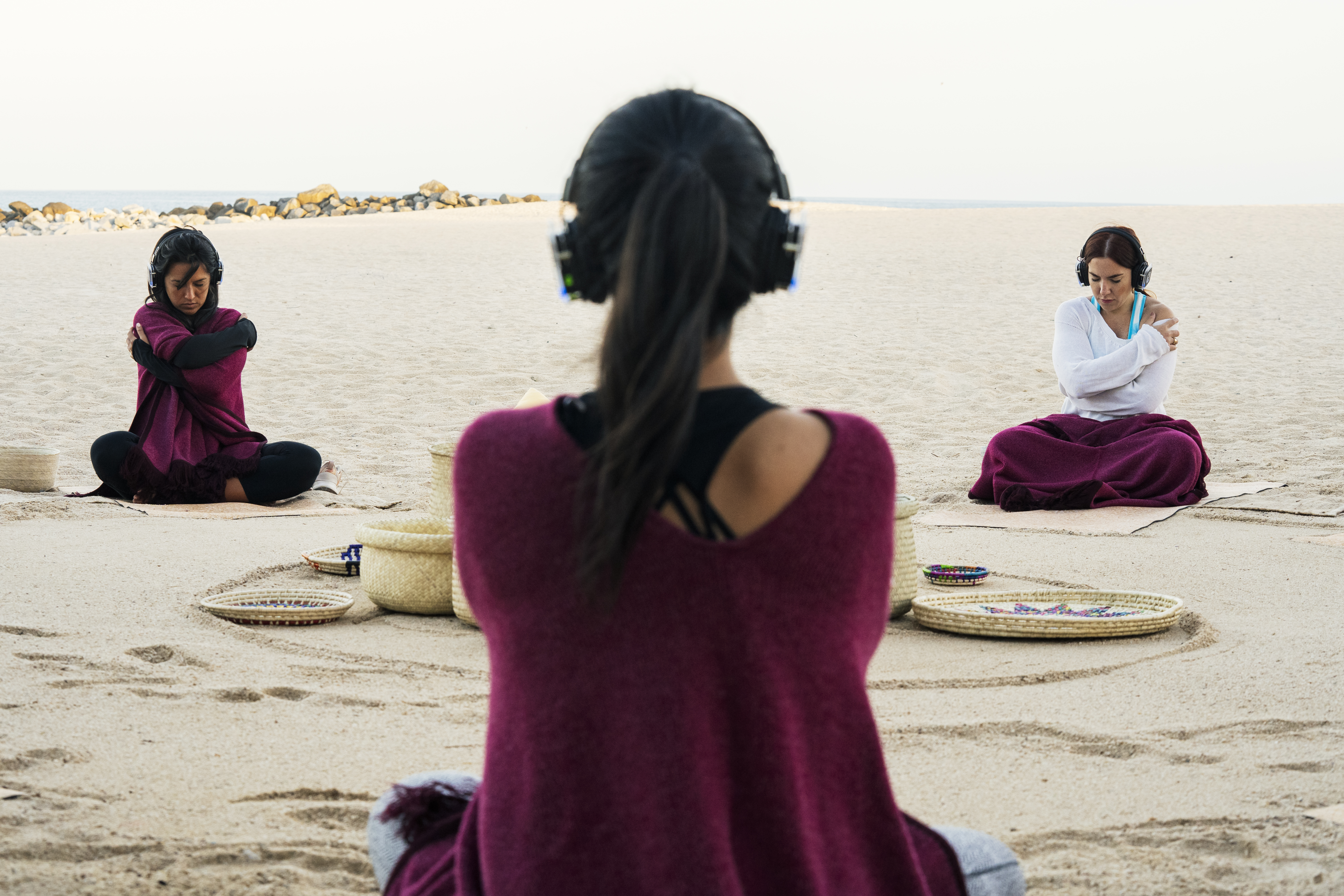 a group of people sitting on the sand