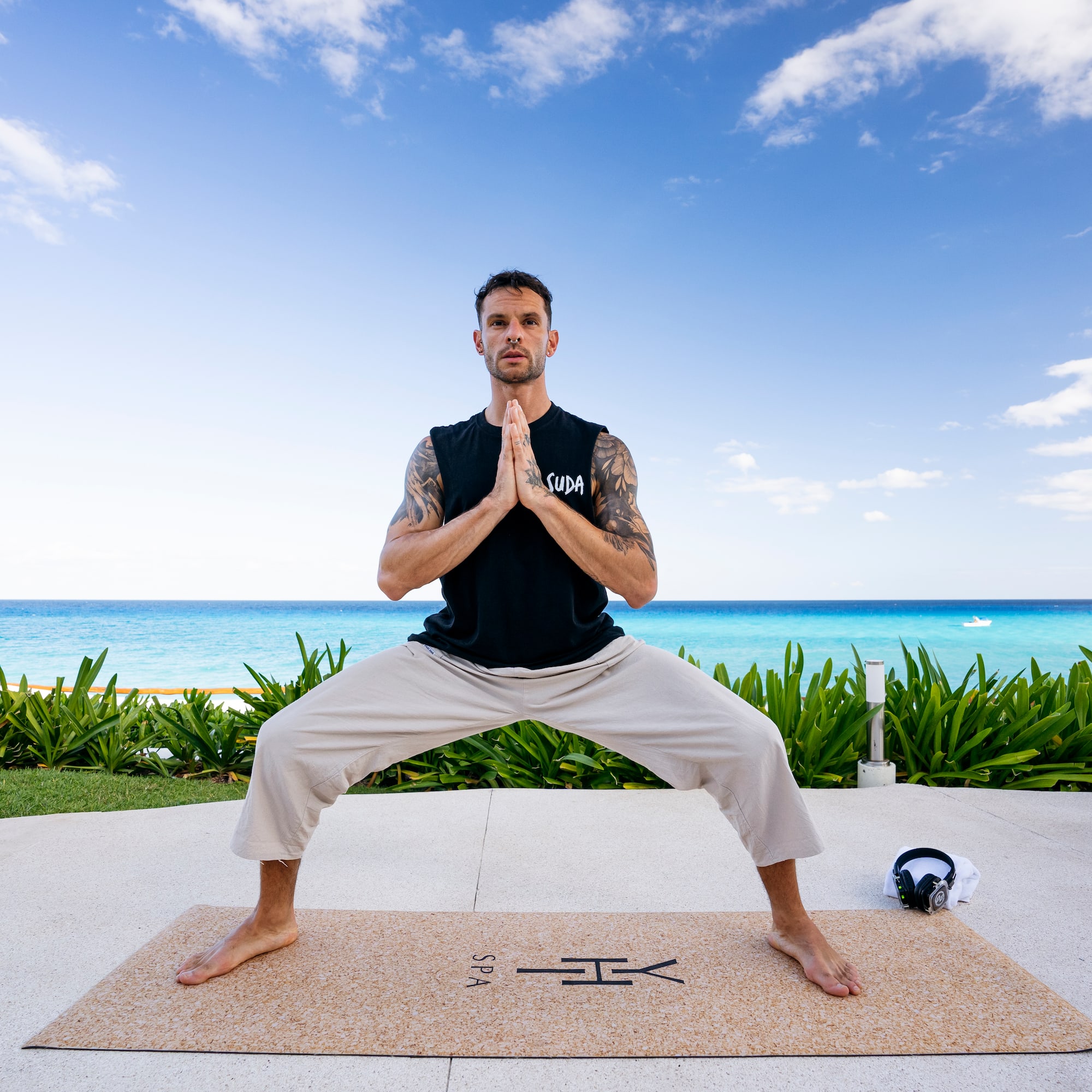 a man standing on a mat with his hands together