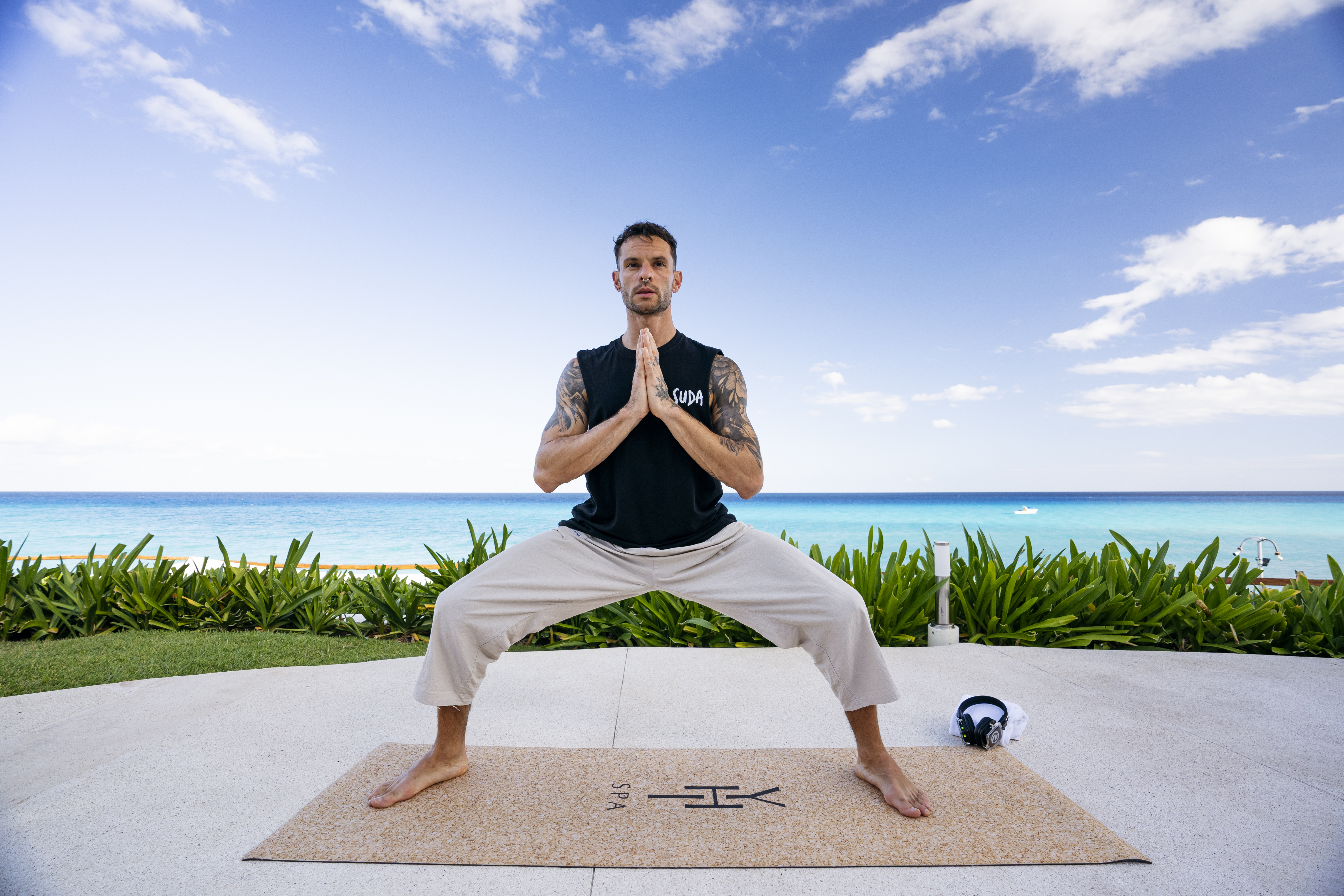 a man standing on a mat with his hands together