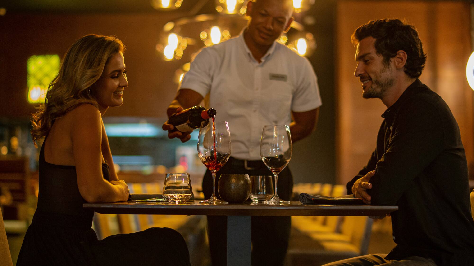 a man pouring wine into a woman's glass