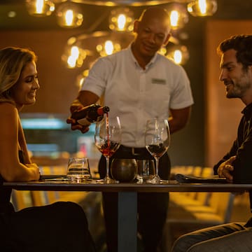 a man pouring wine into a woman's glass