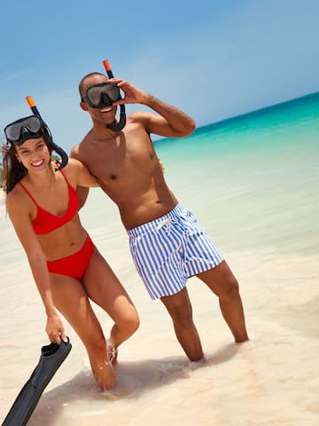 a man and woman in swimsuits on a beach