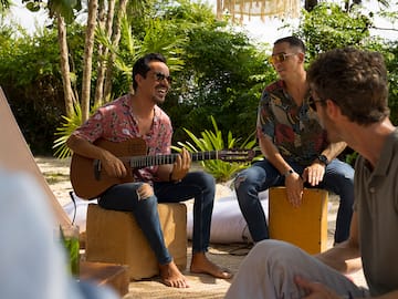 a group of men sitting on boxes playing guitar