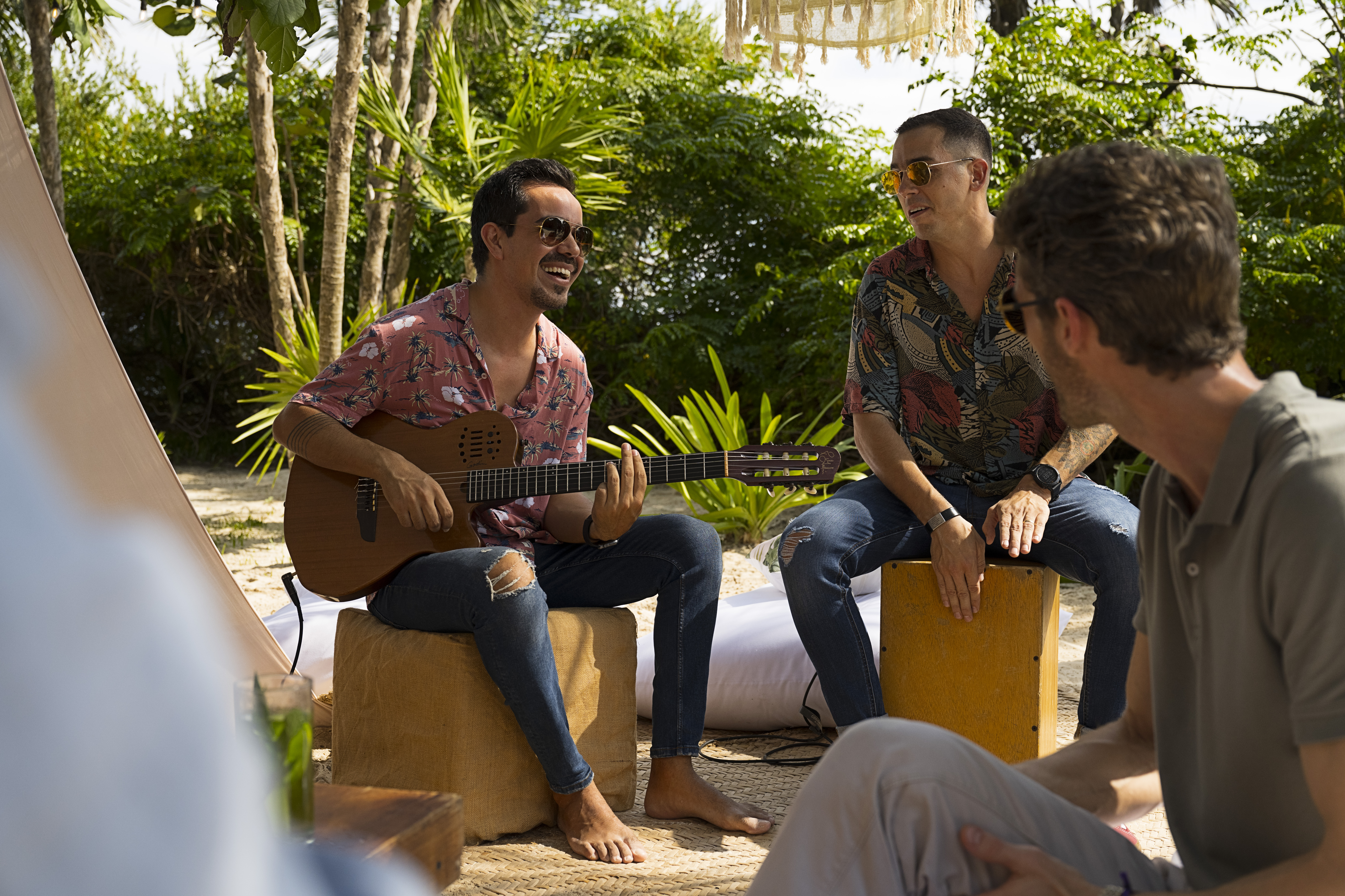 a group of men sitting on boxes playing guitar