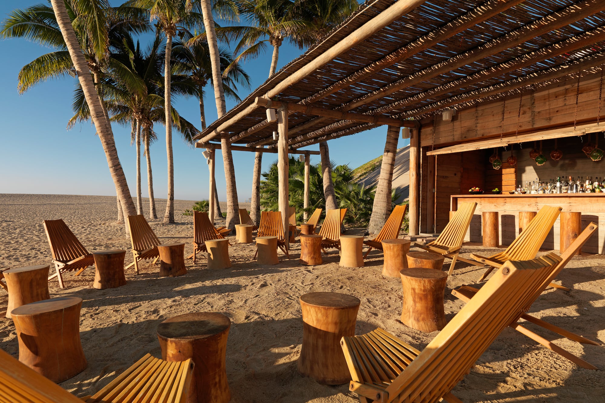 a group of chairs and tables on a beach