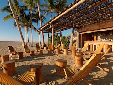 a group of chairs and tables on a beach