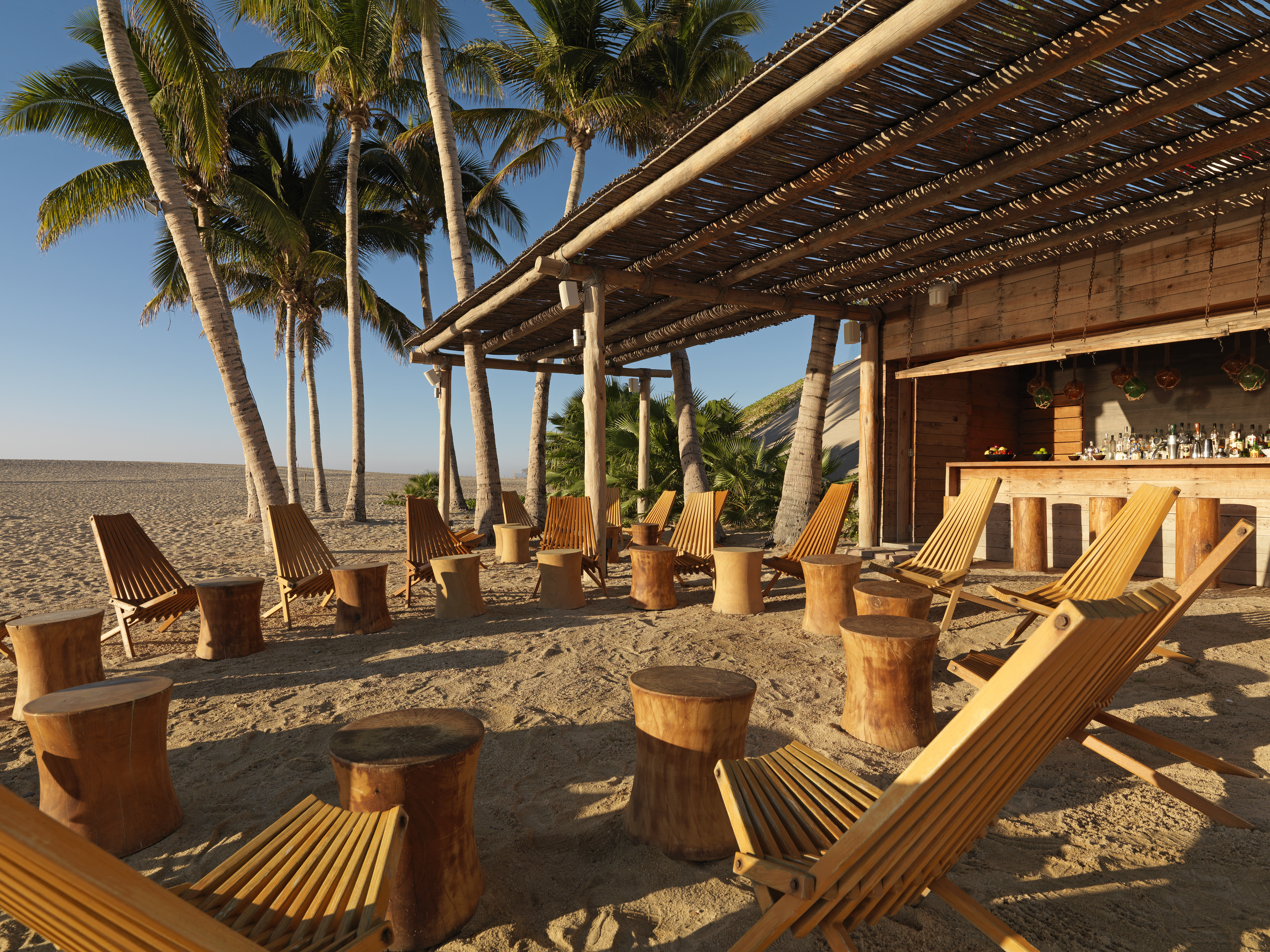 a group of chairs and tables on a beach