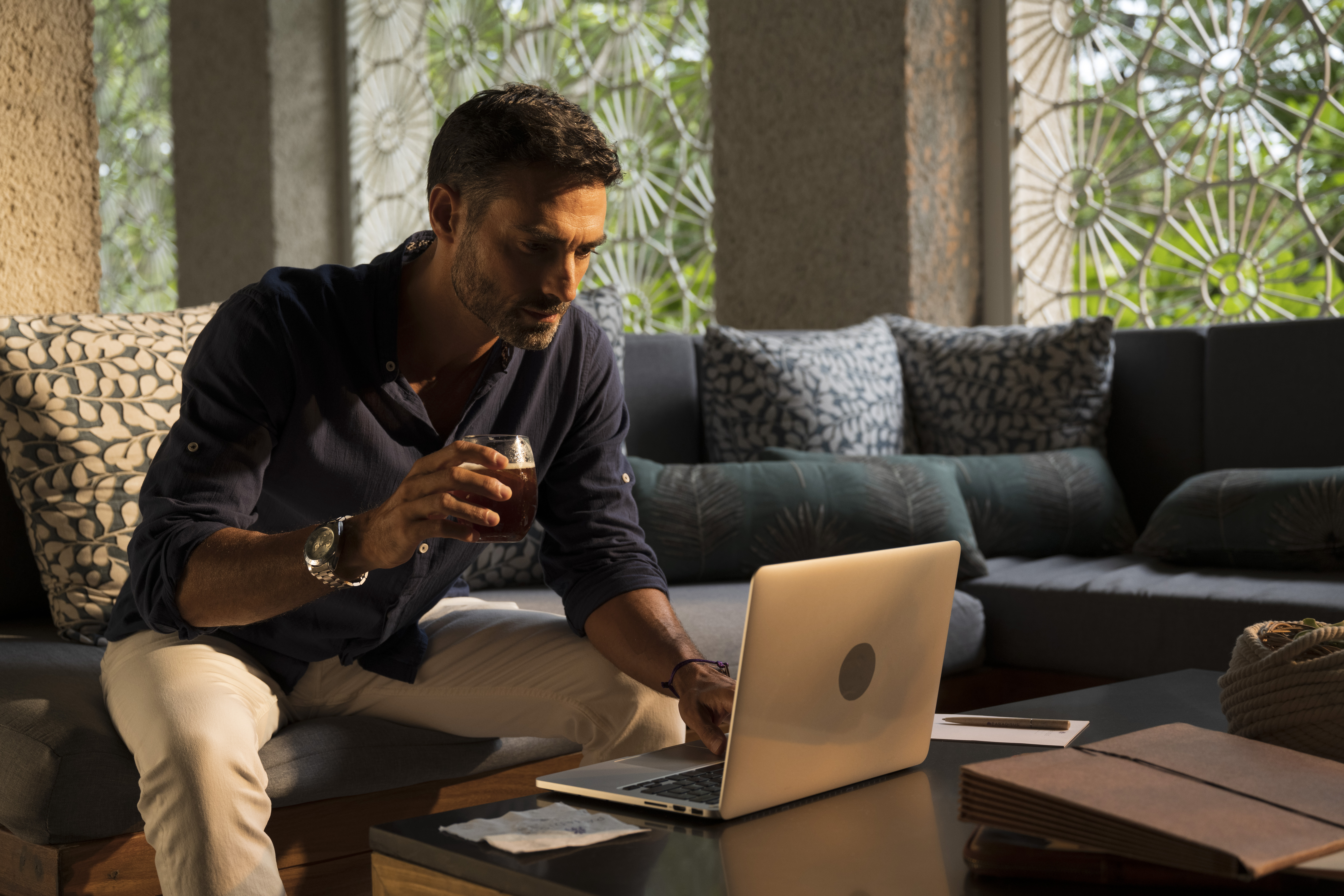 a man sitting on a couch using a laptop