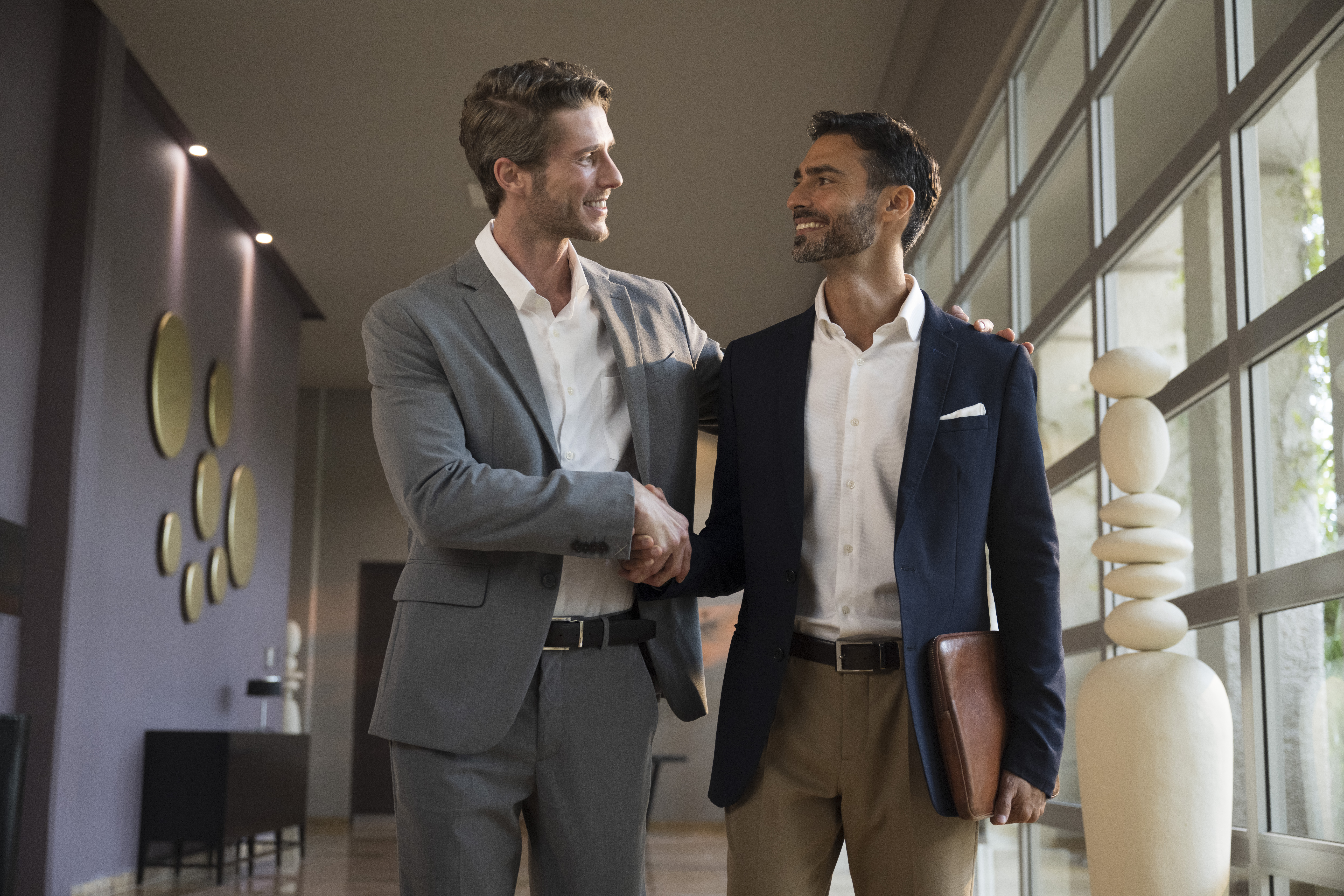two men shaking hands in a room