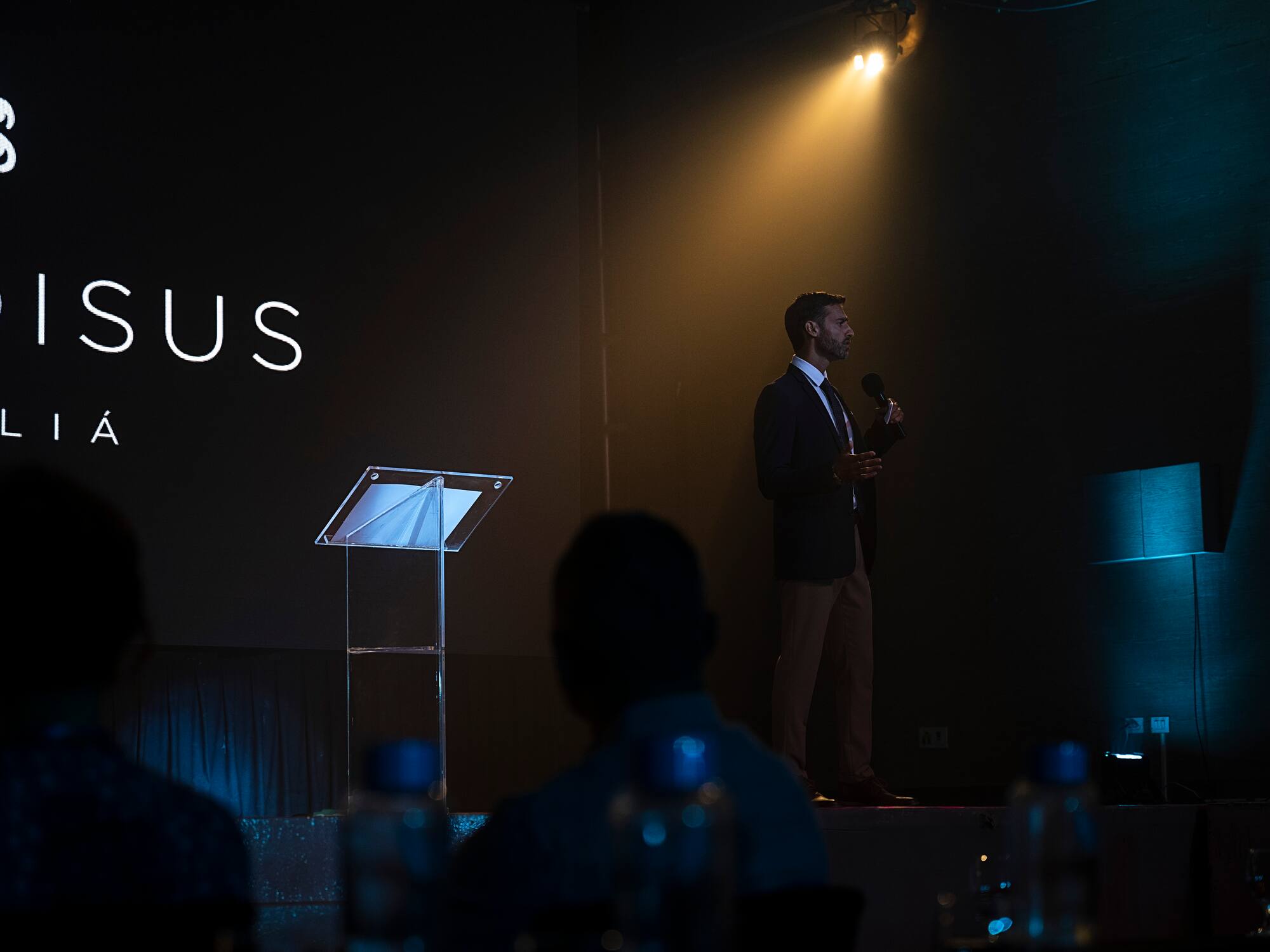 a man standing on a stage holding a microphone