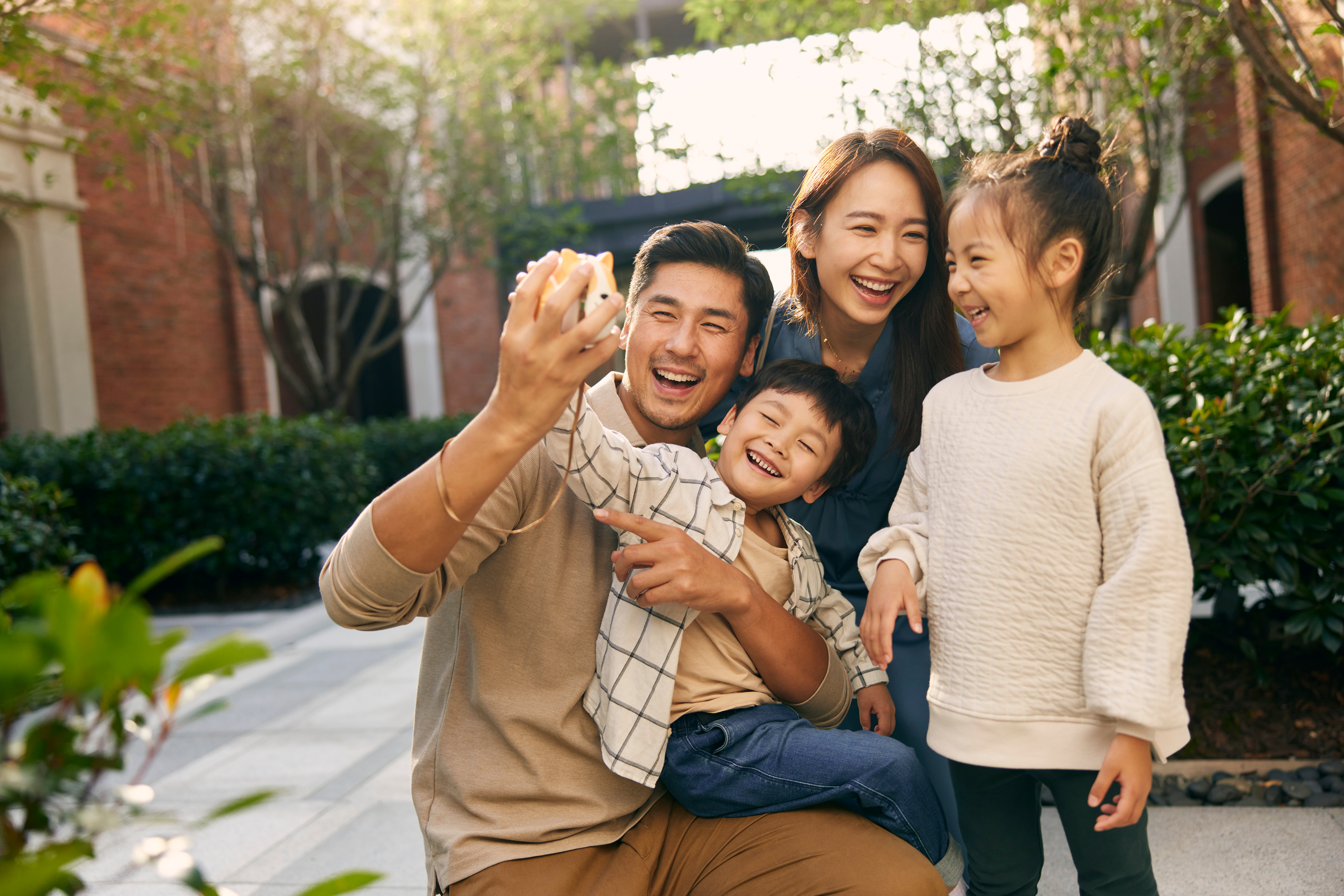 a man and woman taking a selfie with children