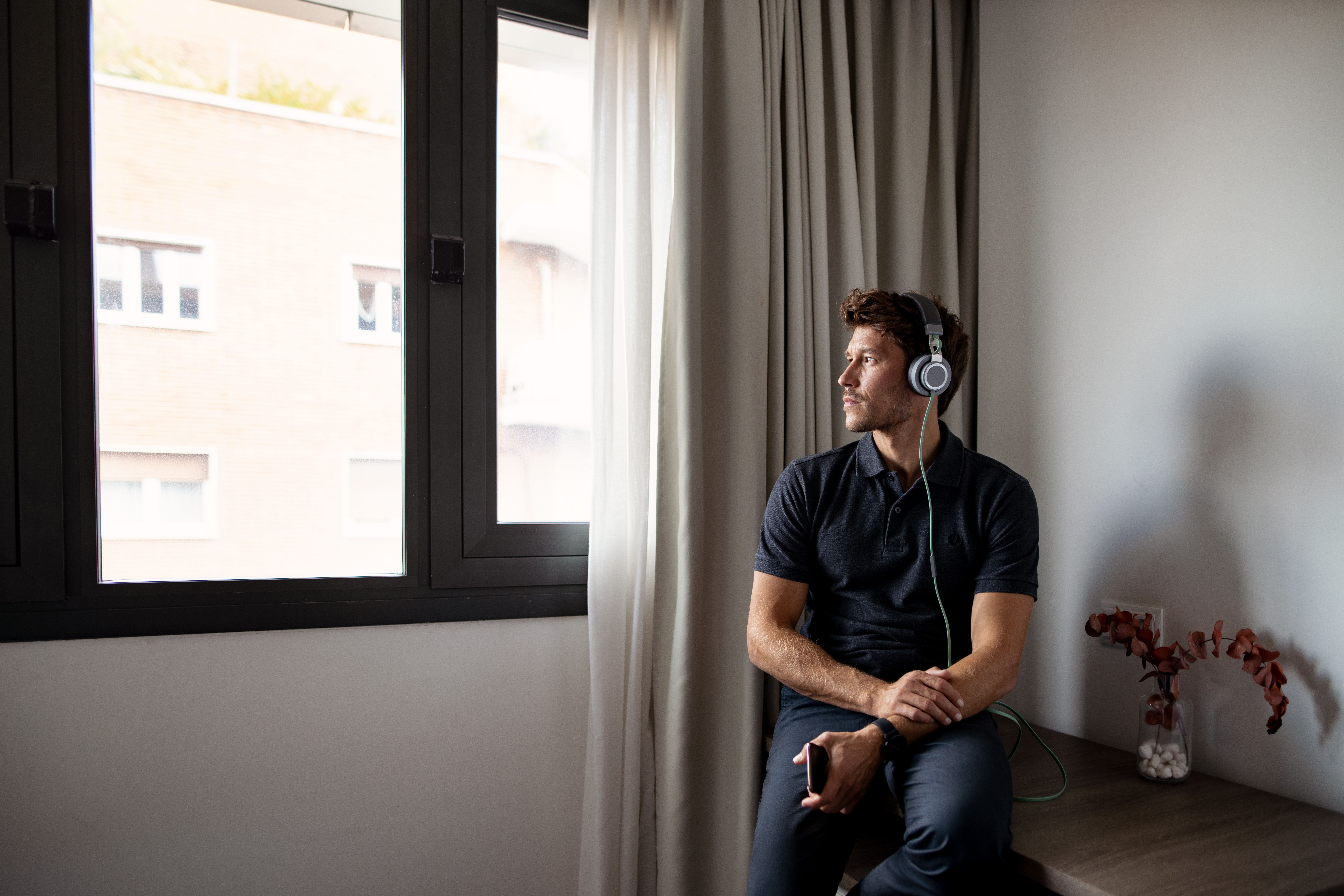 a man sitting on a bench wearing headphones