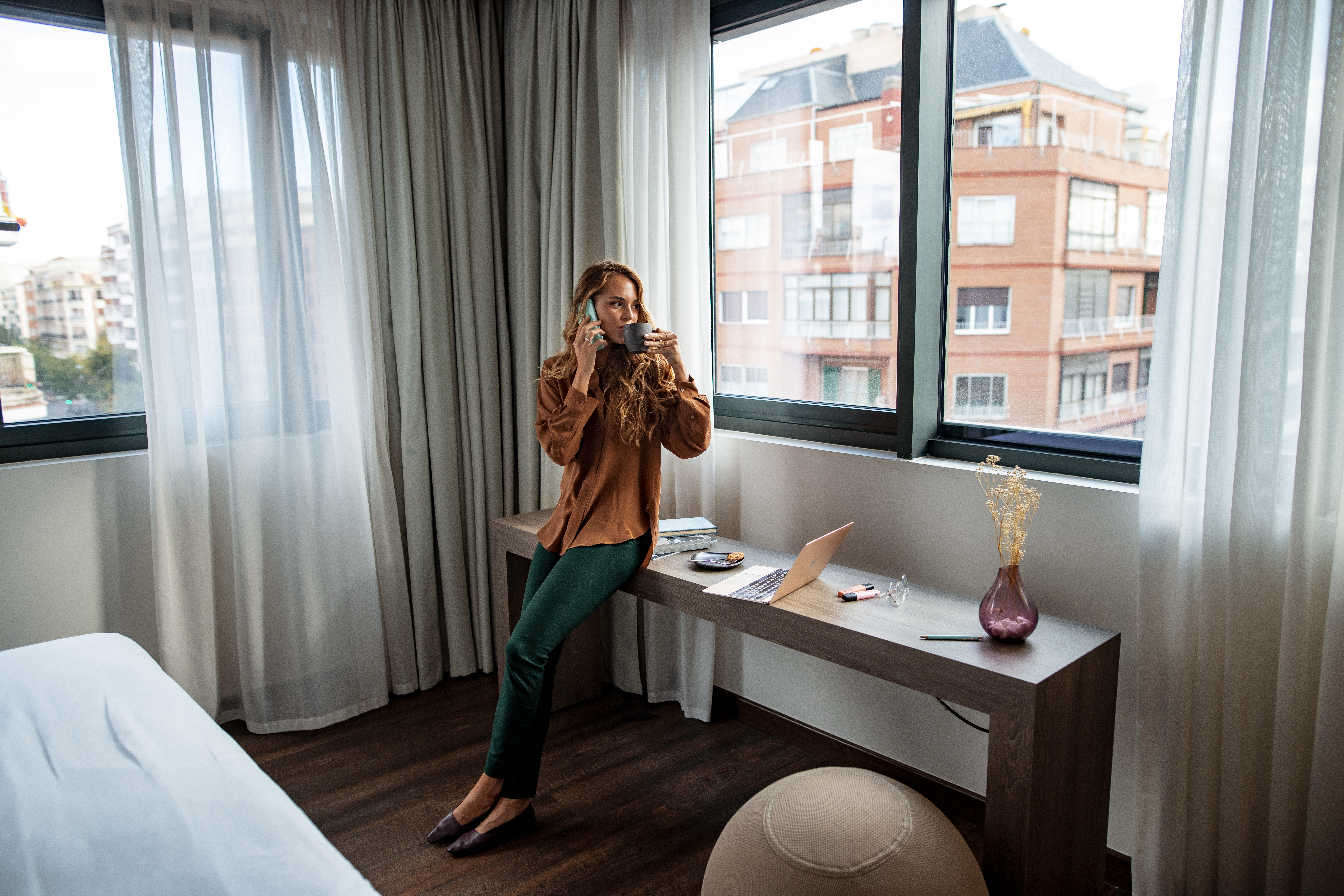a woman sitting on a desk talking on a phone