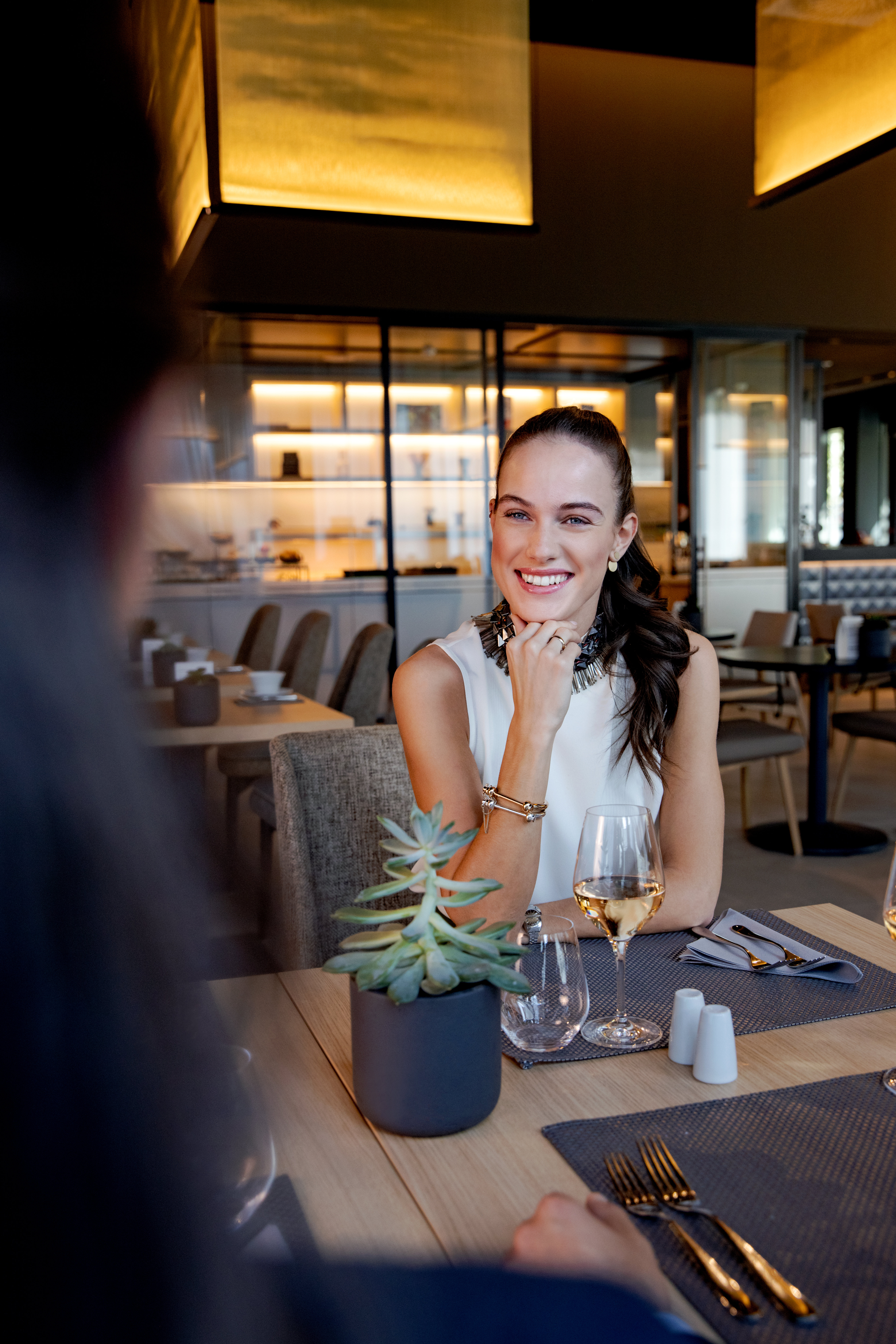 a woman sitting at a table with wine glasses