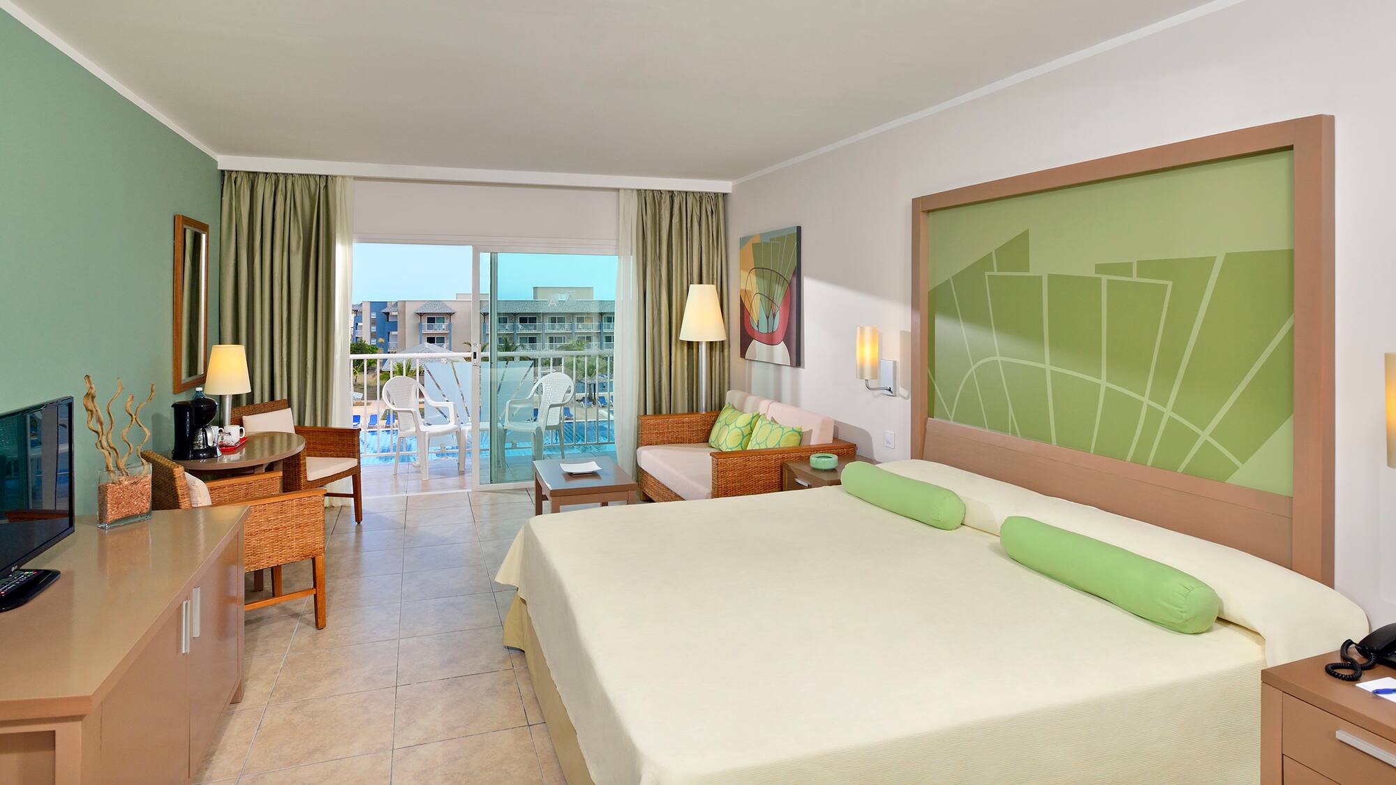 a room with a bed and chairs and a balcony