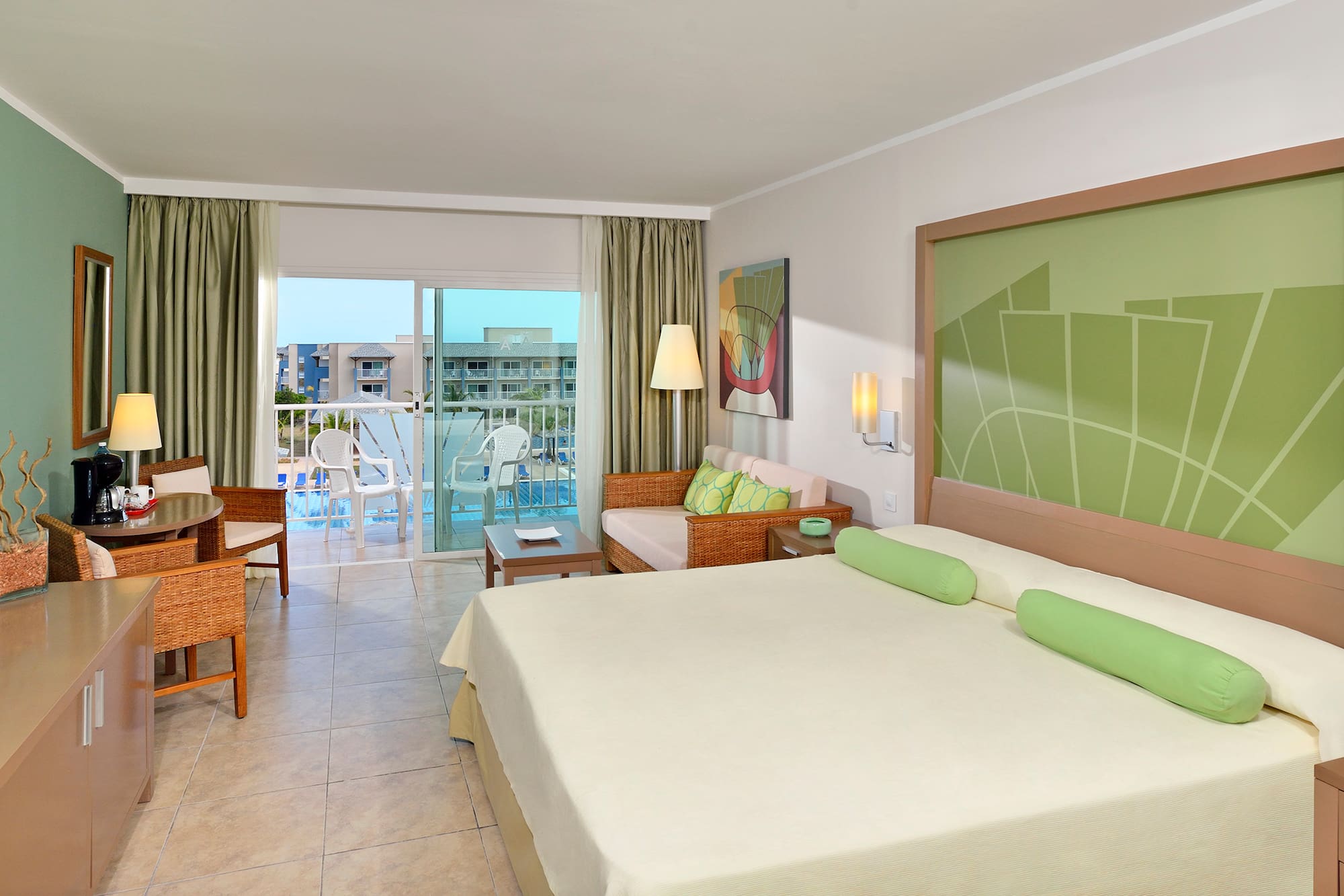 a room with a bed and chairs and a balcony