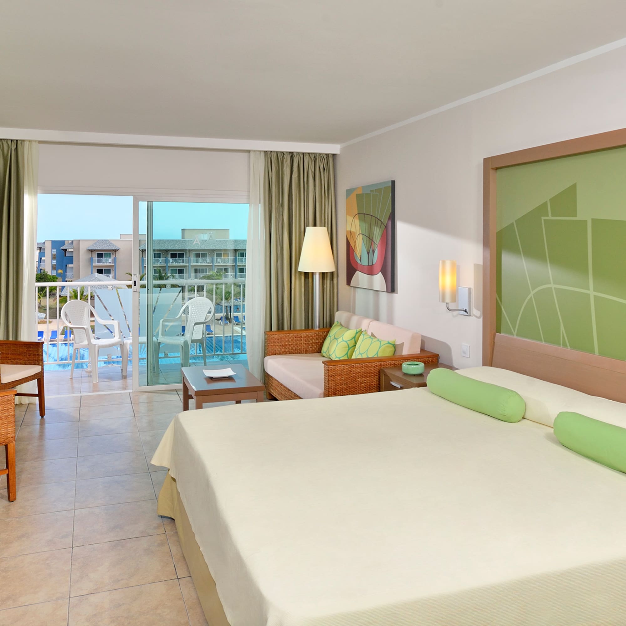 a room with a bed and chairs and a balcony