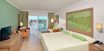 a room with a bed and chairs and a balcony