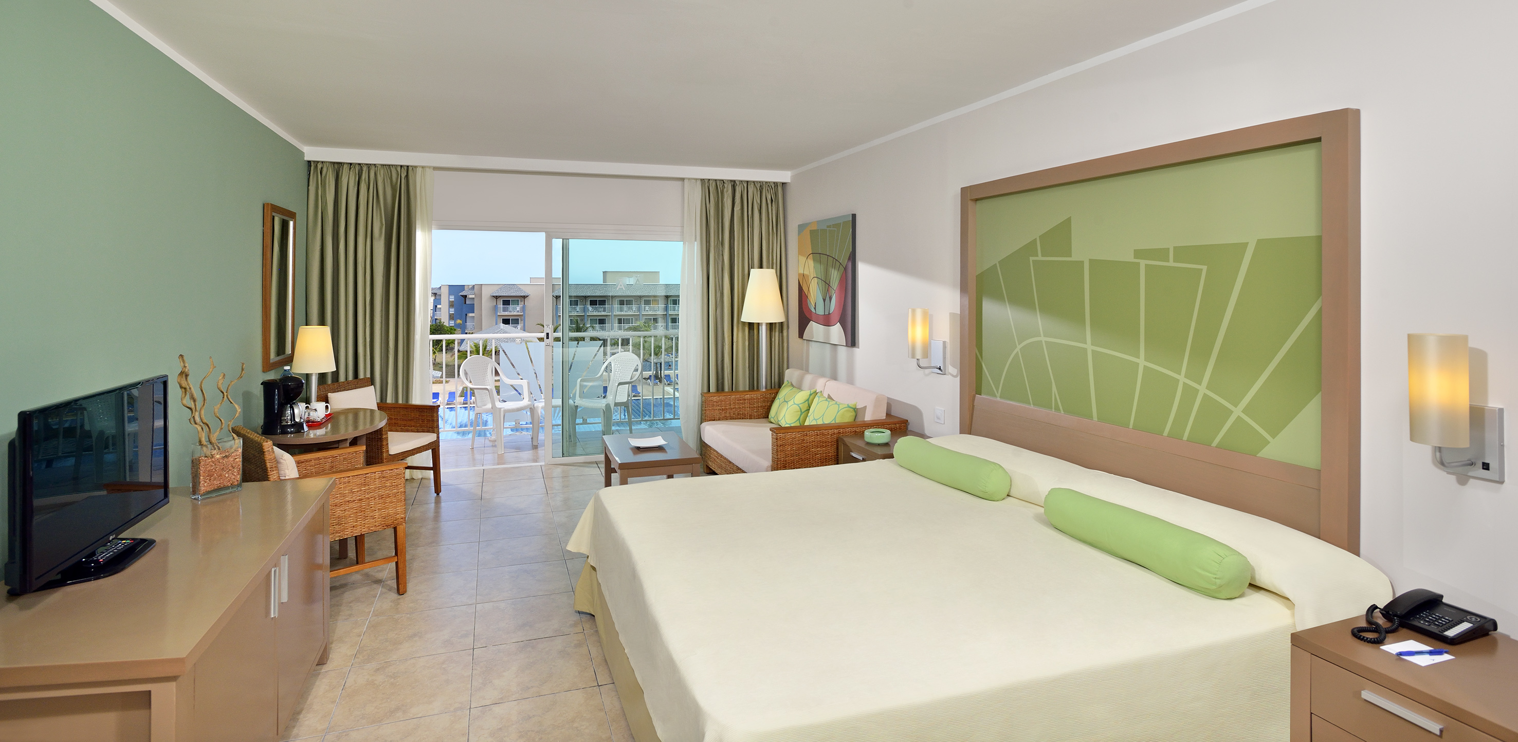 a room with a bed and chairs and a balcony