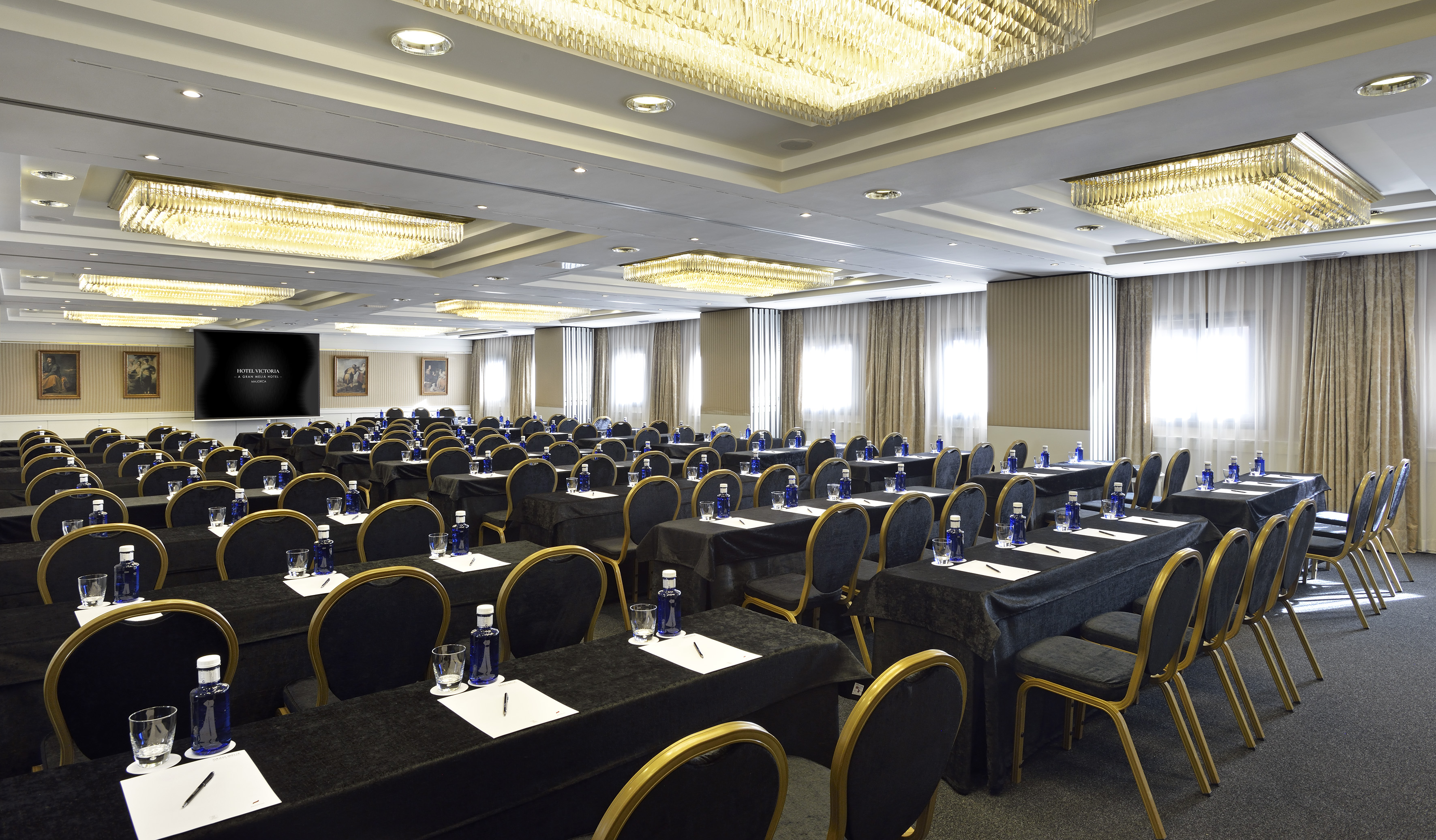 Hotel Victoria elegant conference room set for meetings with projector screen.