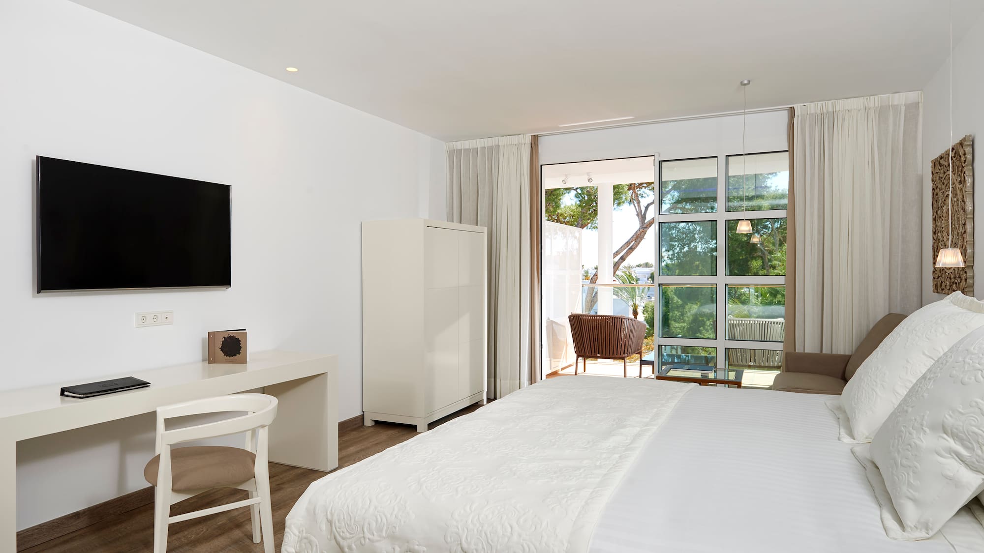 a bedroom with a bed and a desk and a television