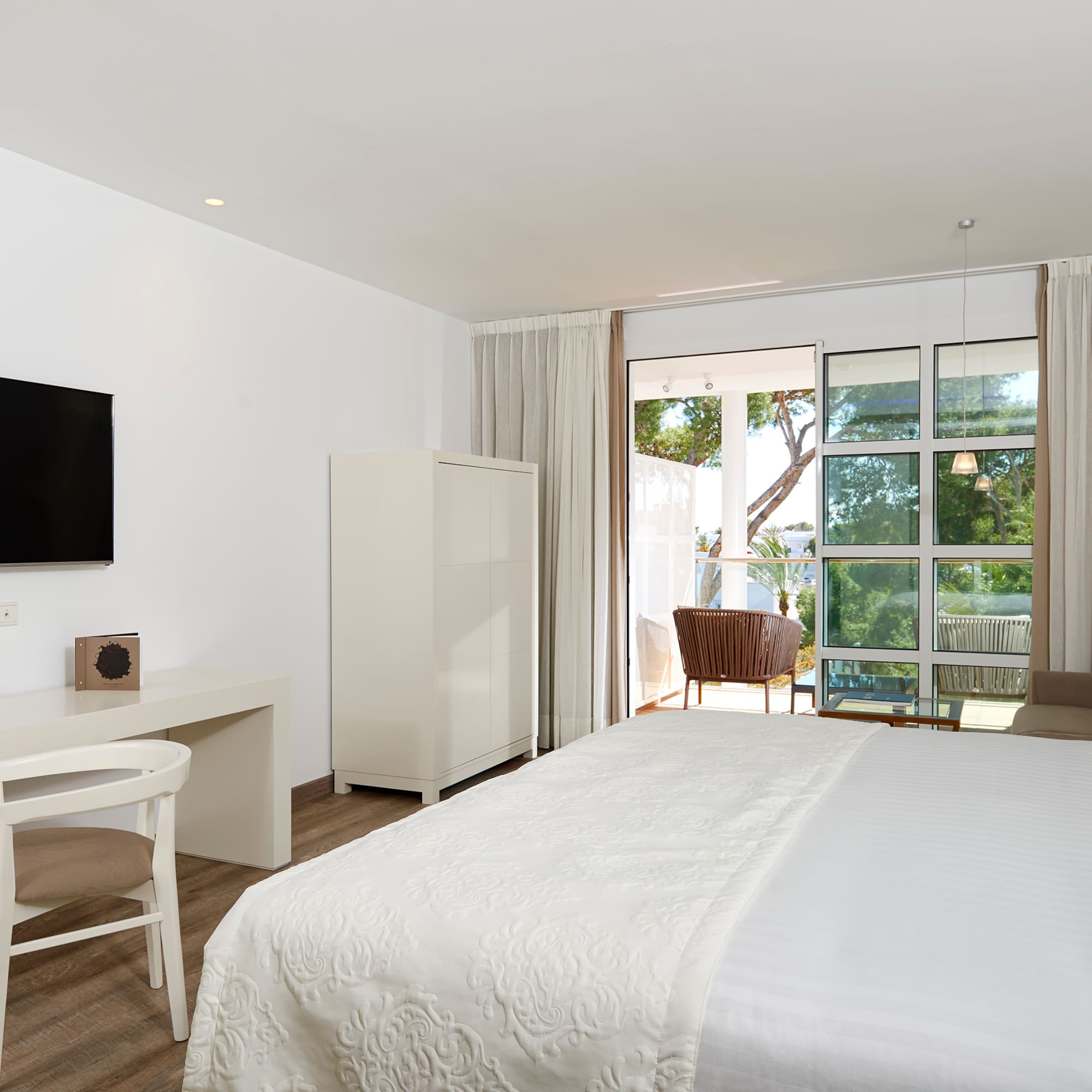 a bedroom with a bed and a desk and a television