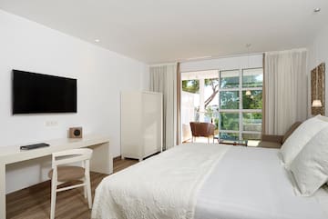 a bedroom with a bed and a desk and a television