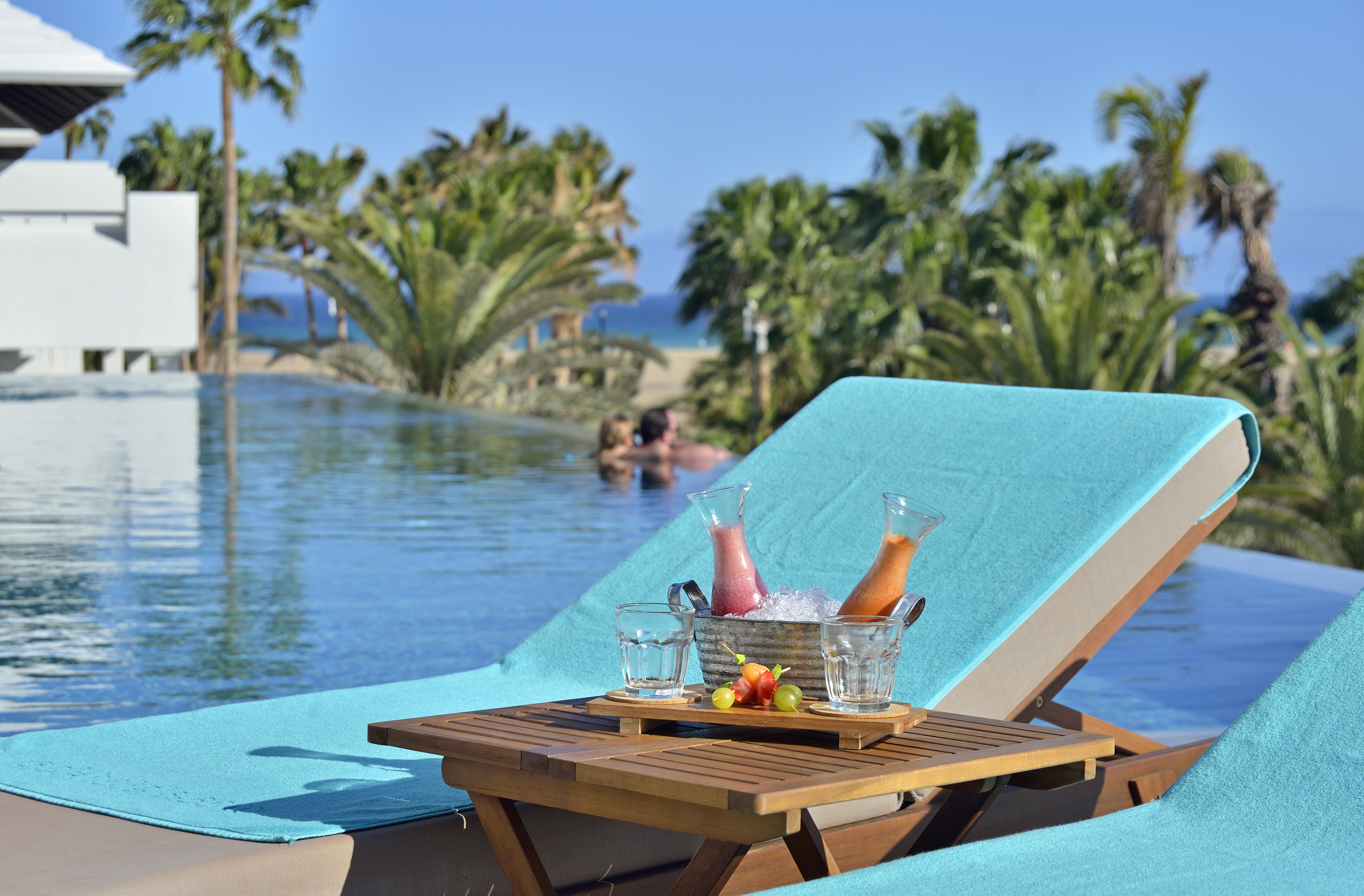 a table with drinks on it by a pool