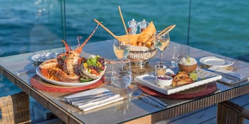 a table with plates of food and glasses of wine