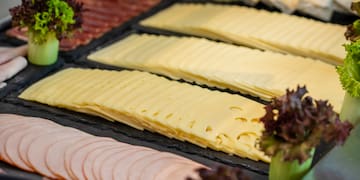 a tray of sliced meat and cheese