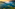a green hills with trees and a sunset