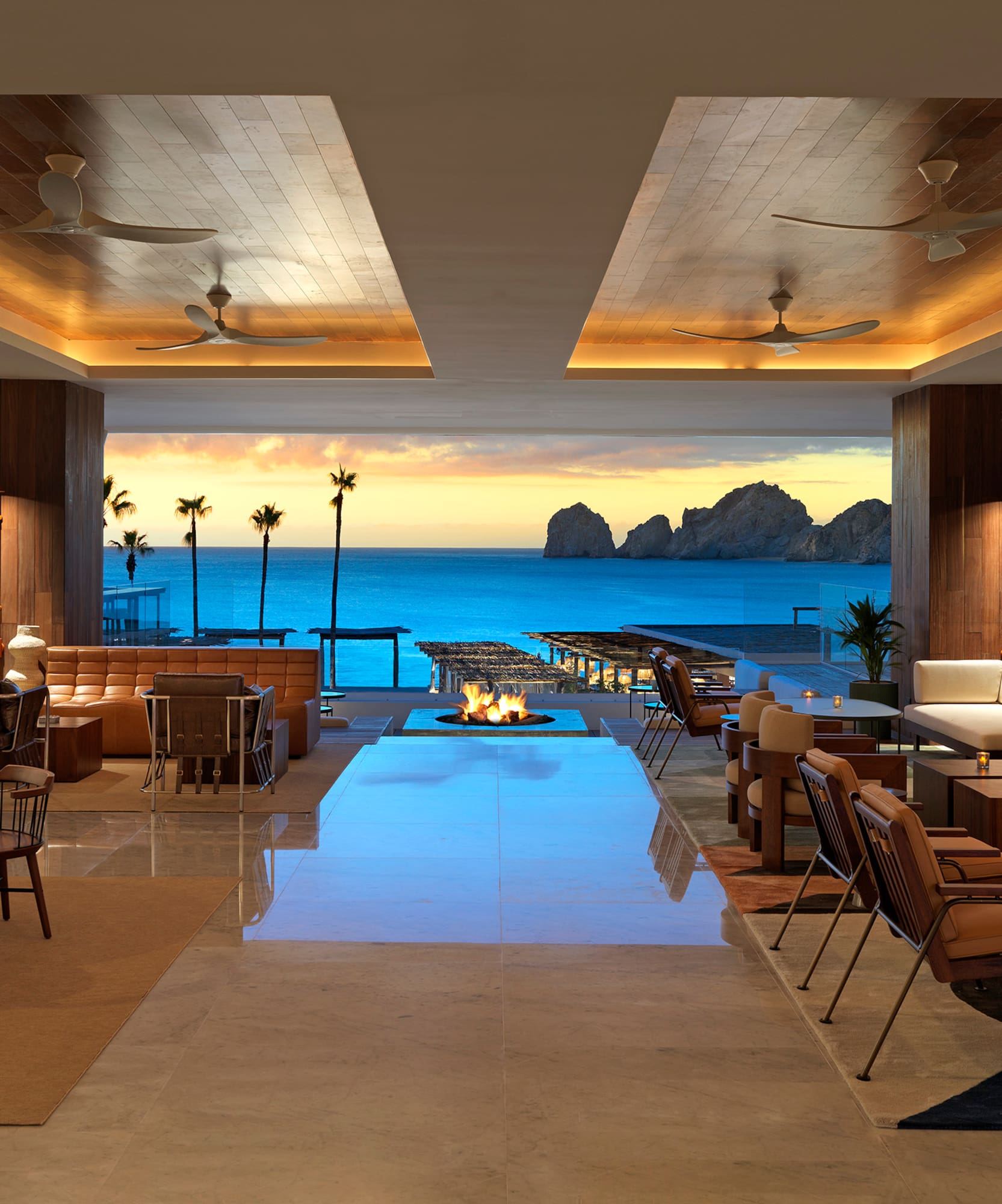 a room with a fire pit and chairs