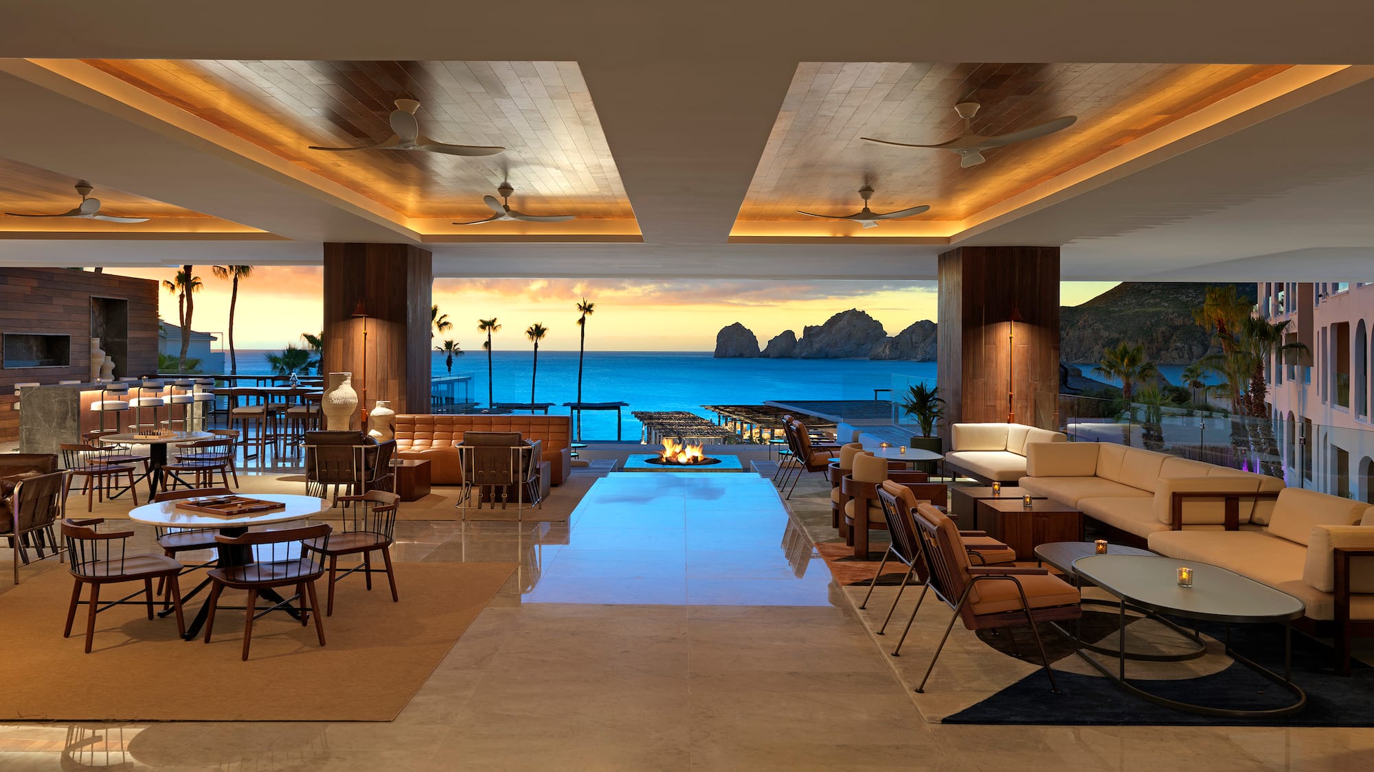 a room with a fire pit and chairs