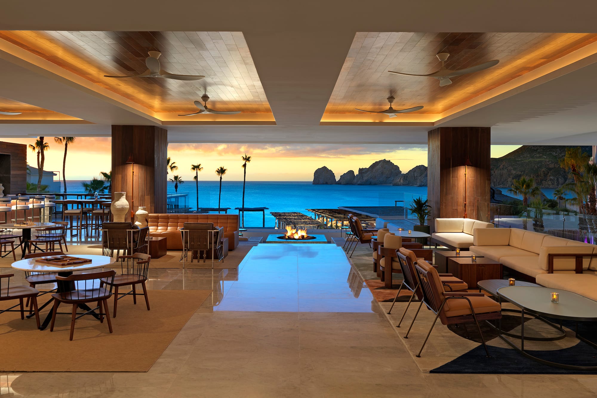 a room with a fire pit and chairs