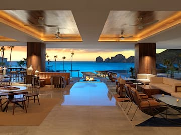 a room with a fire pit and chairs
