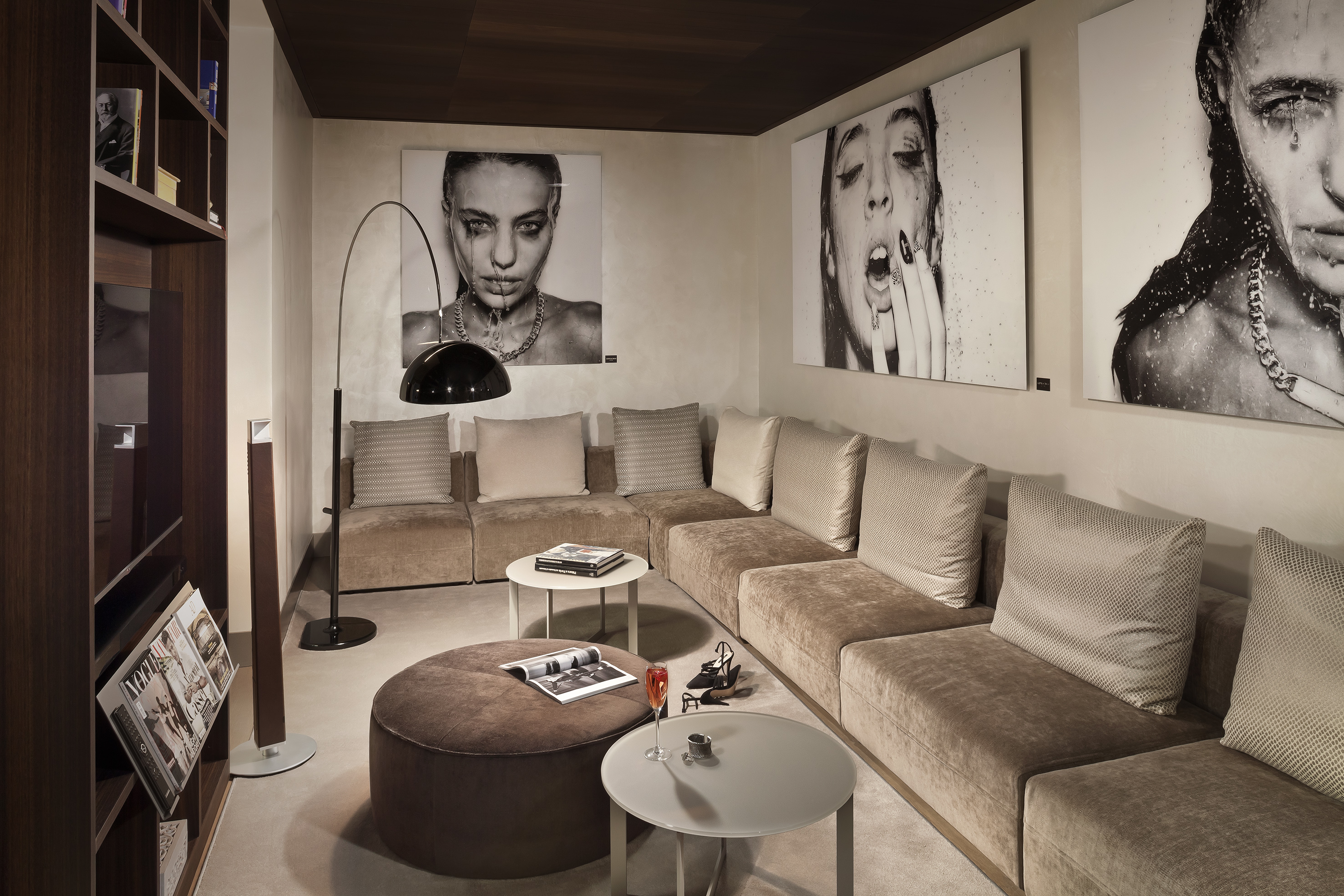 Modern lounge with large modular sofa, contemporary art, and dark wood shelving.