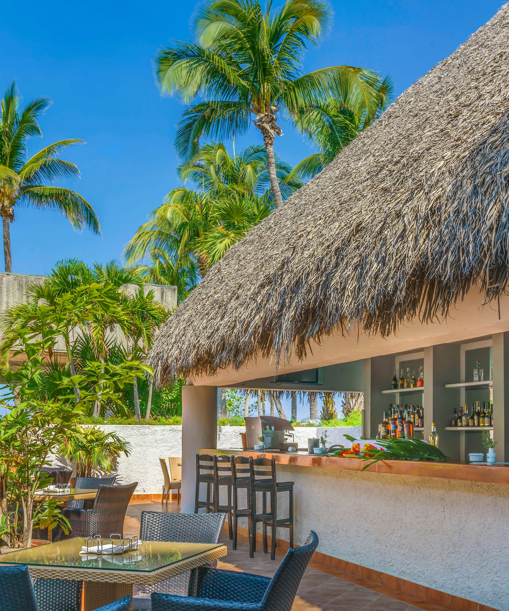 a bar with a thatched roof and tables and chairs