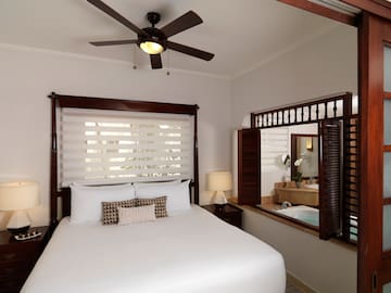 a bed with a fan and a window