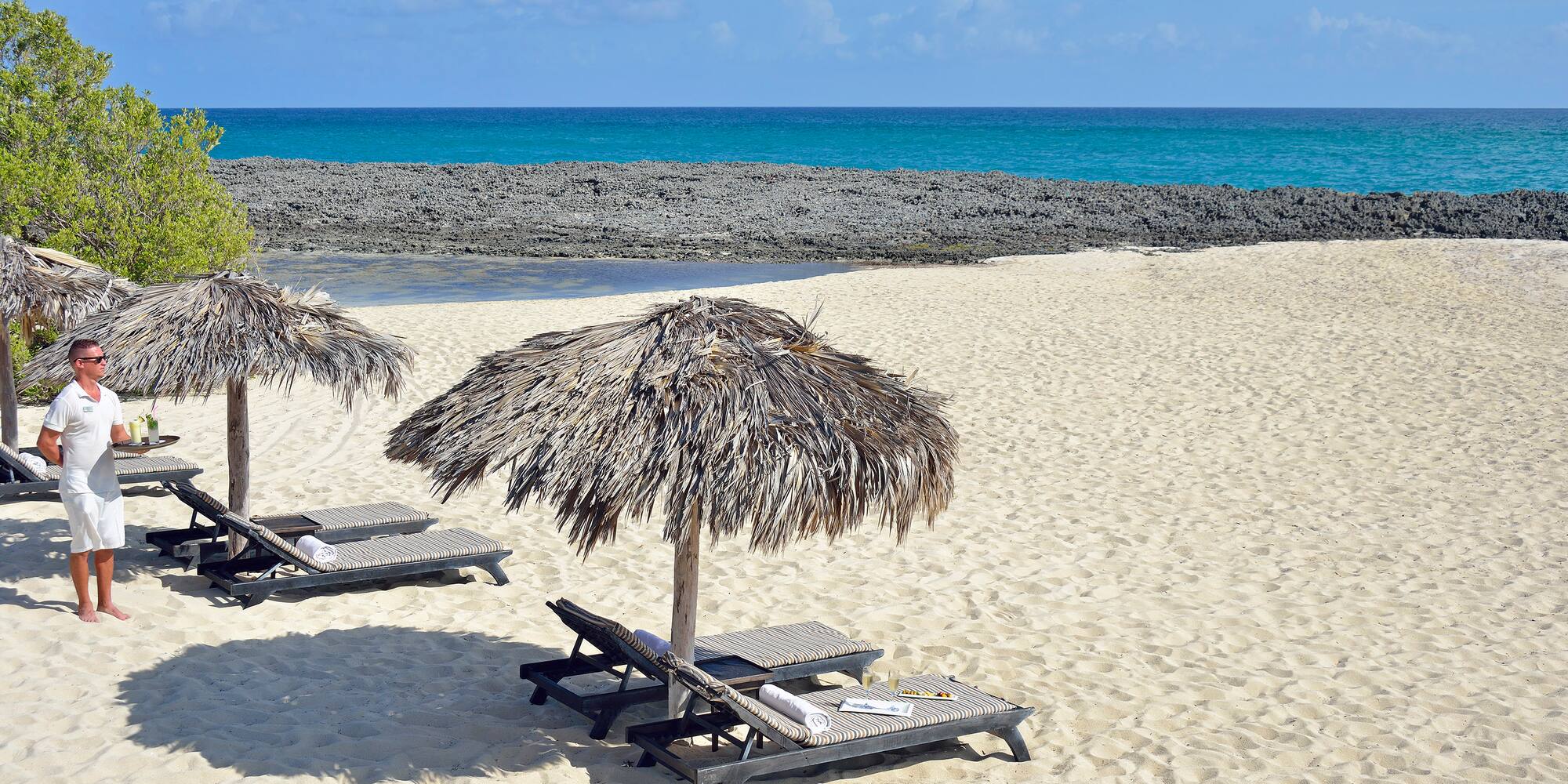 a beach with chairs and umbrellas