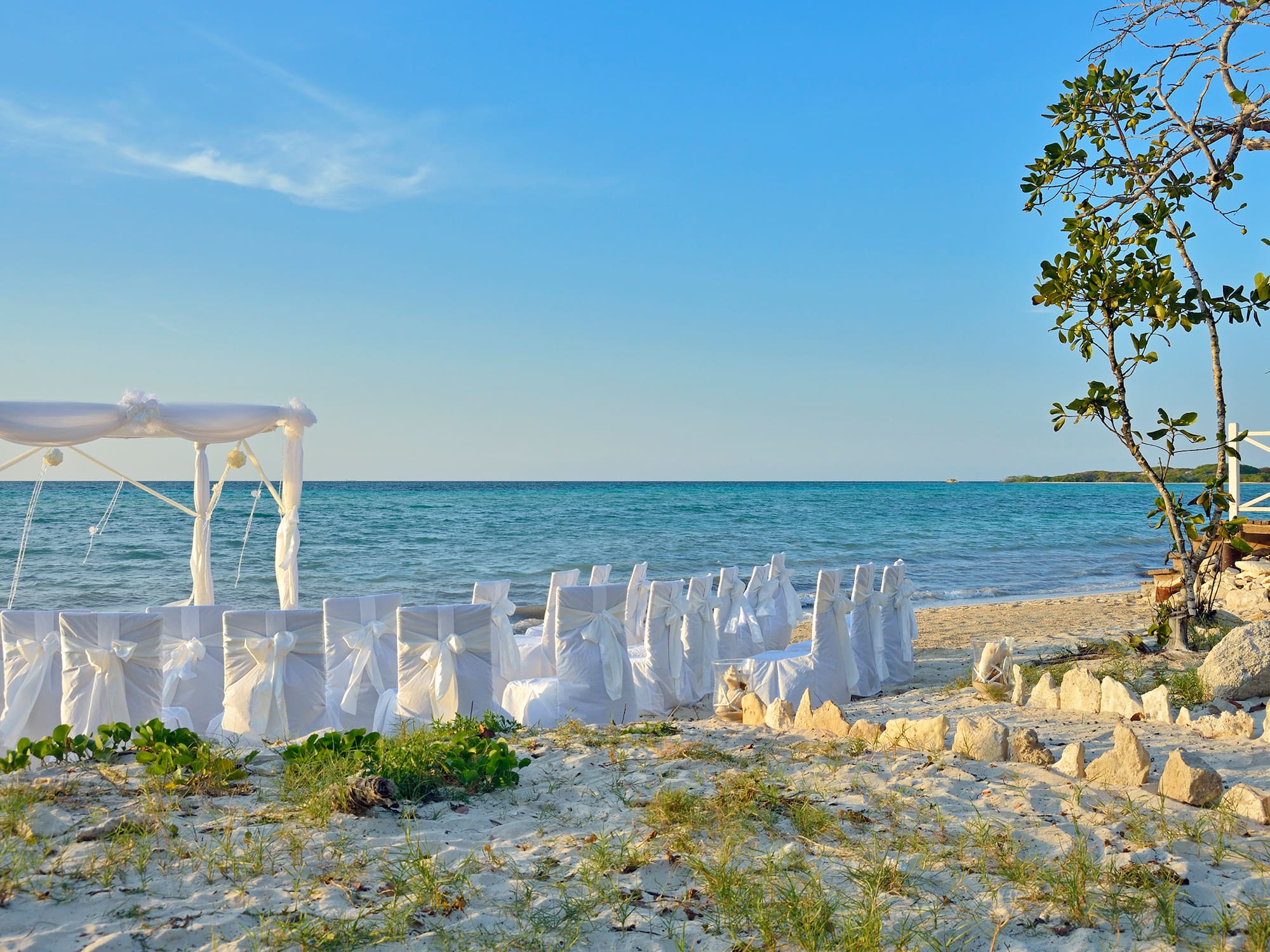 a beach with chairs and a canopy