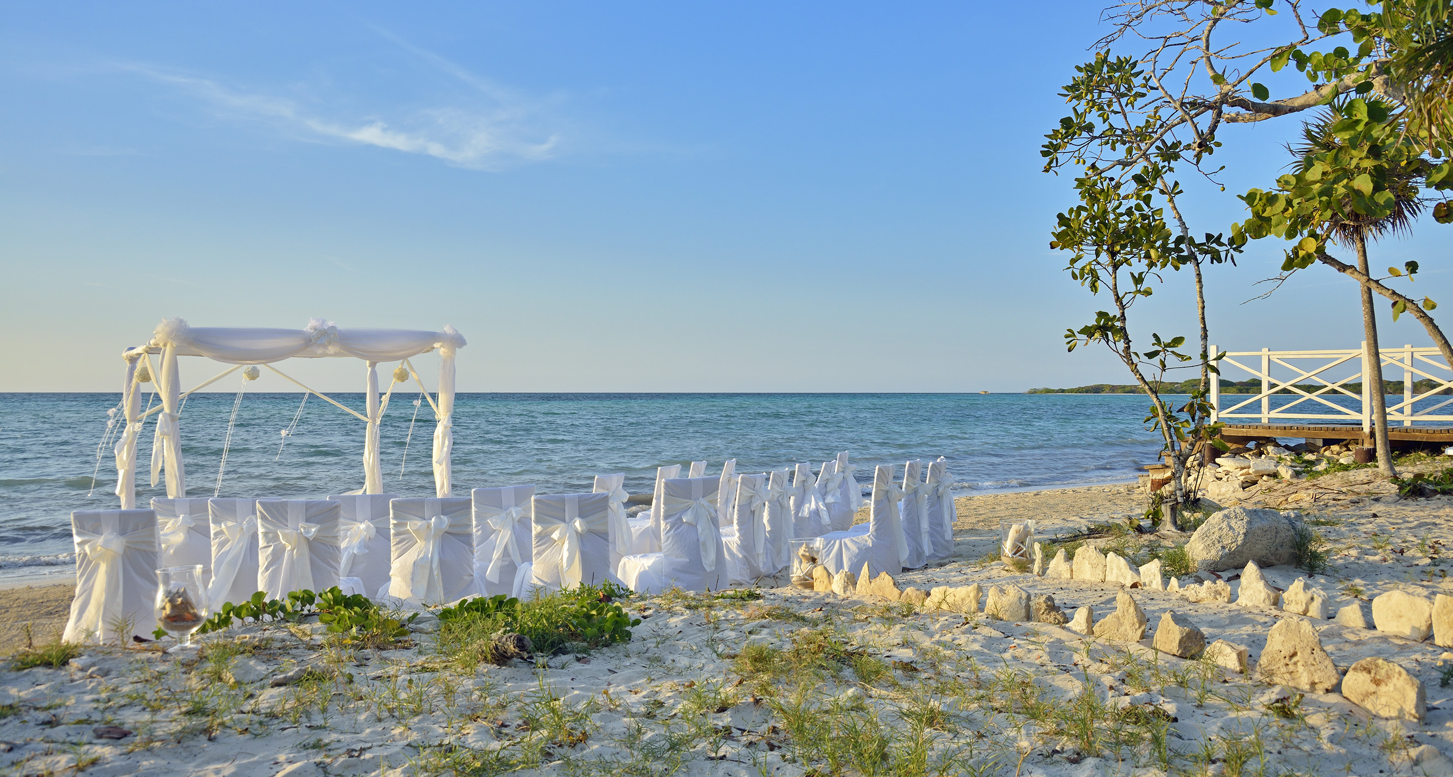 a beach with chairs and a canopy