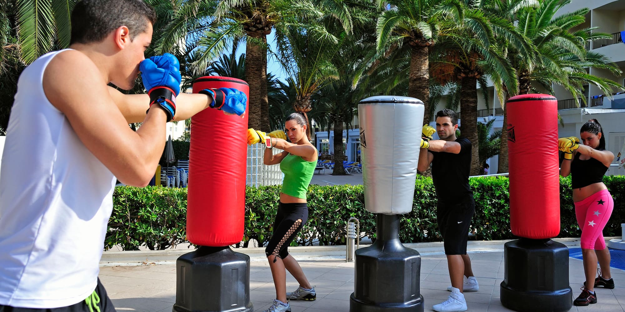 a group of people punching bags outside