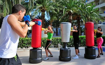 a group of people punching bags outside