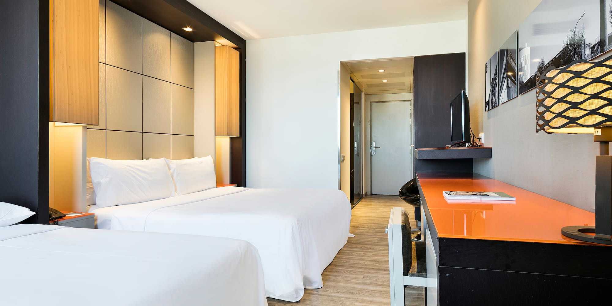 a room with two beds and a desk